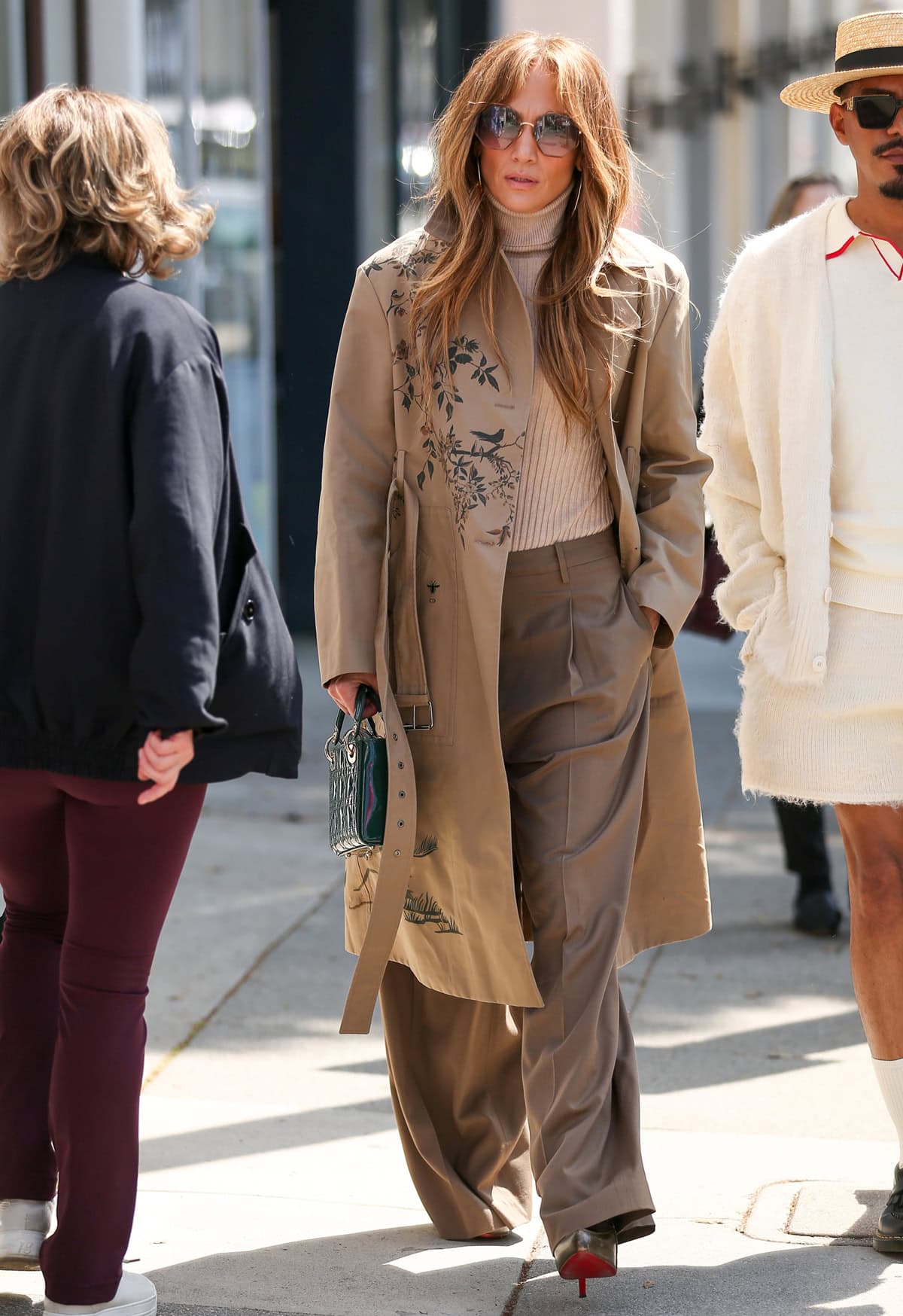 Jennifer Lopez stepped out in Brentwood on May 19, 2024, wearing a Dior trench coat, Dior Mini Lady Dior bag in pine green patent cannage calfskin, Chloe 0046 octagonal sunglasses in gold, and Christian Louboutin lace-up boots