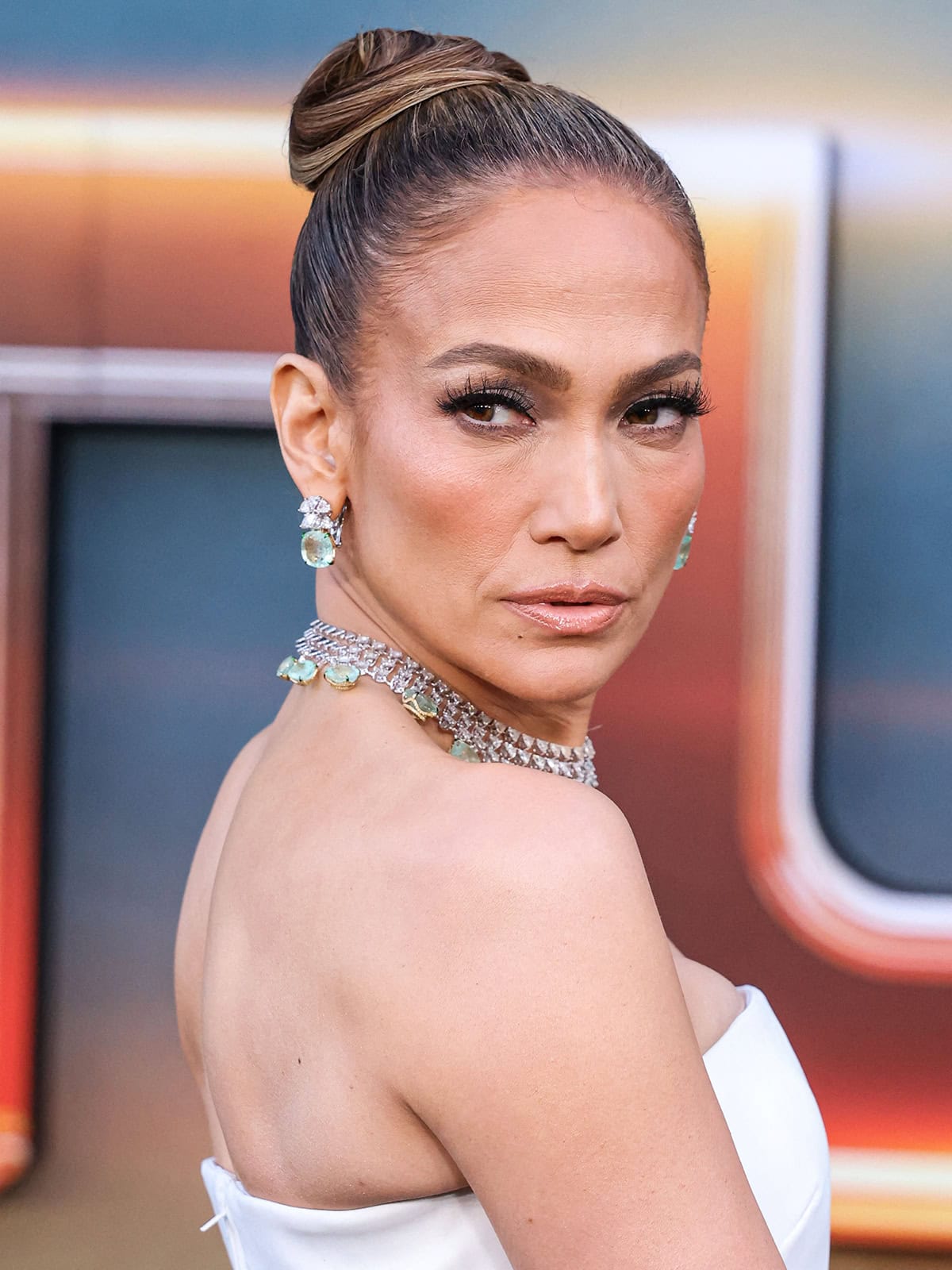 Jennifer Lopez accentuates her eyes with fluttery eyelashes and smokey eyeshadow and styles her hair in a chic and neat updo