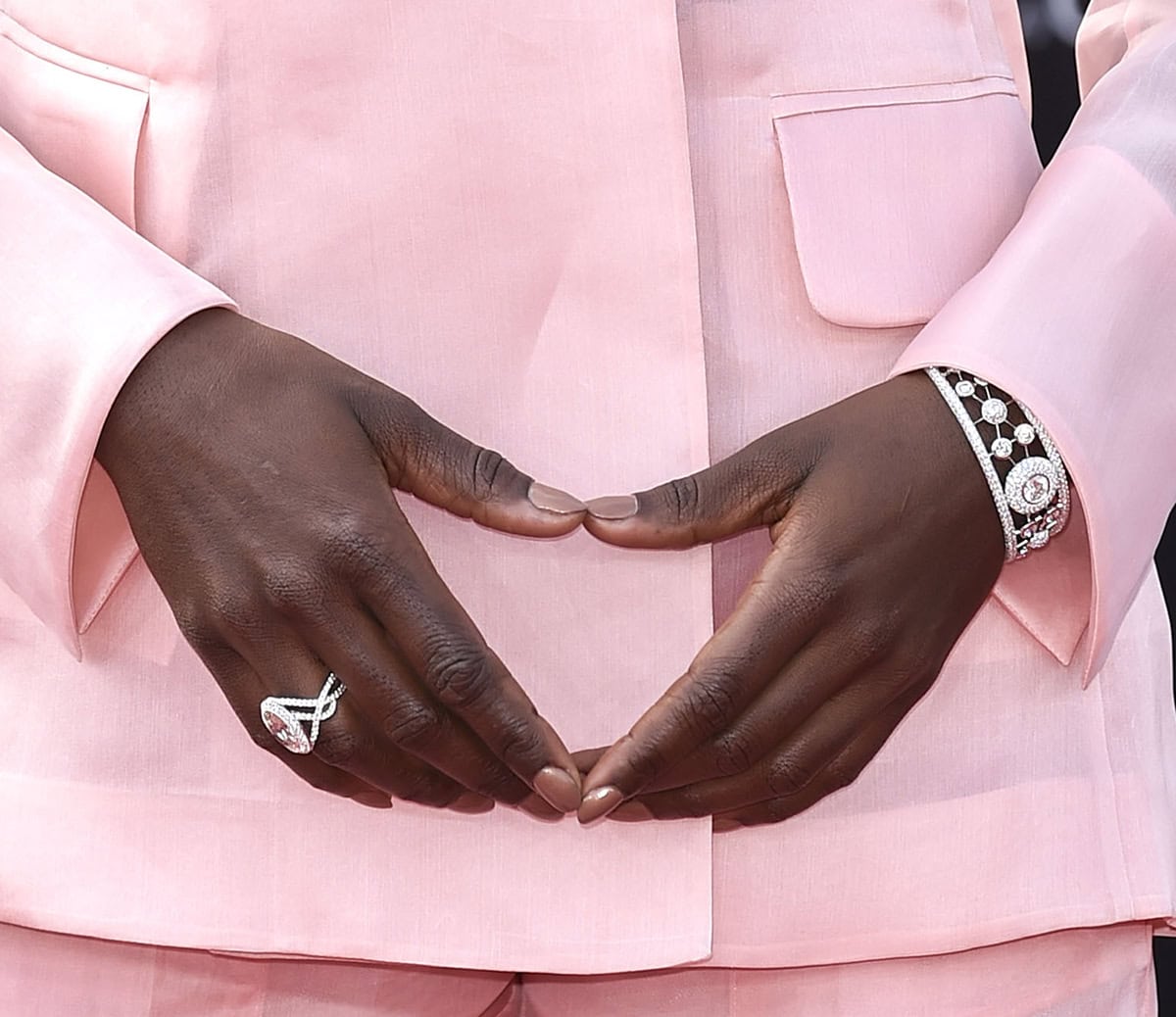 Lupita Nyong'o further enhances her look with a diamond ring and a De Beers Atomique Cuff Bracelet