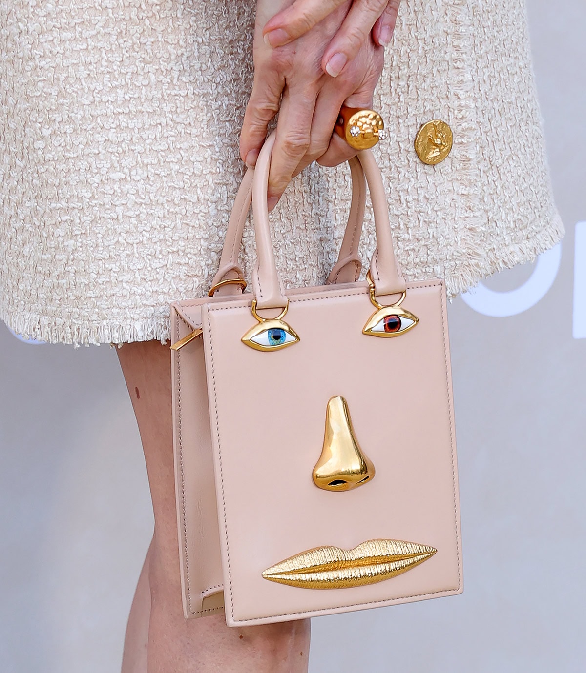 Michelle Yeoh carries her red-carpet essentials in the Schiaparelli Mini Anatomy trompe l’oeil face bag, adding an extra fun element to the classic business suit