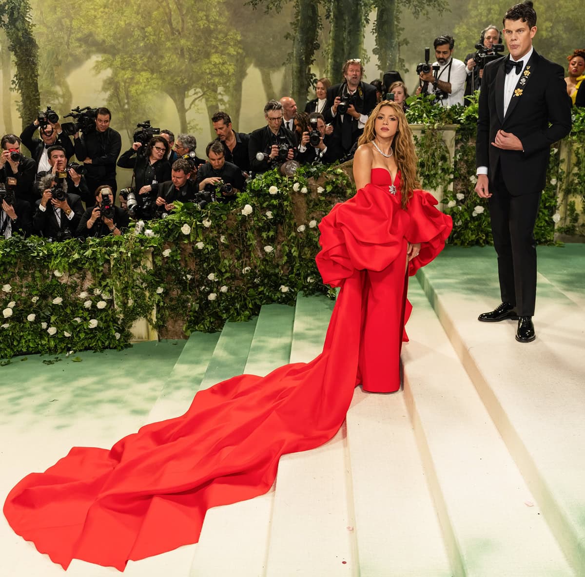 Iconic Duo: Shakira, alongside Wes Gordon, shines in a custom Carolina Herrera gown, showcasing a bold choice in the timeless hue of red