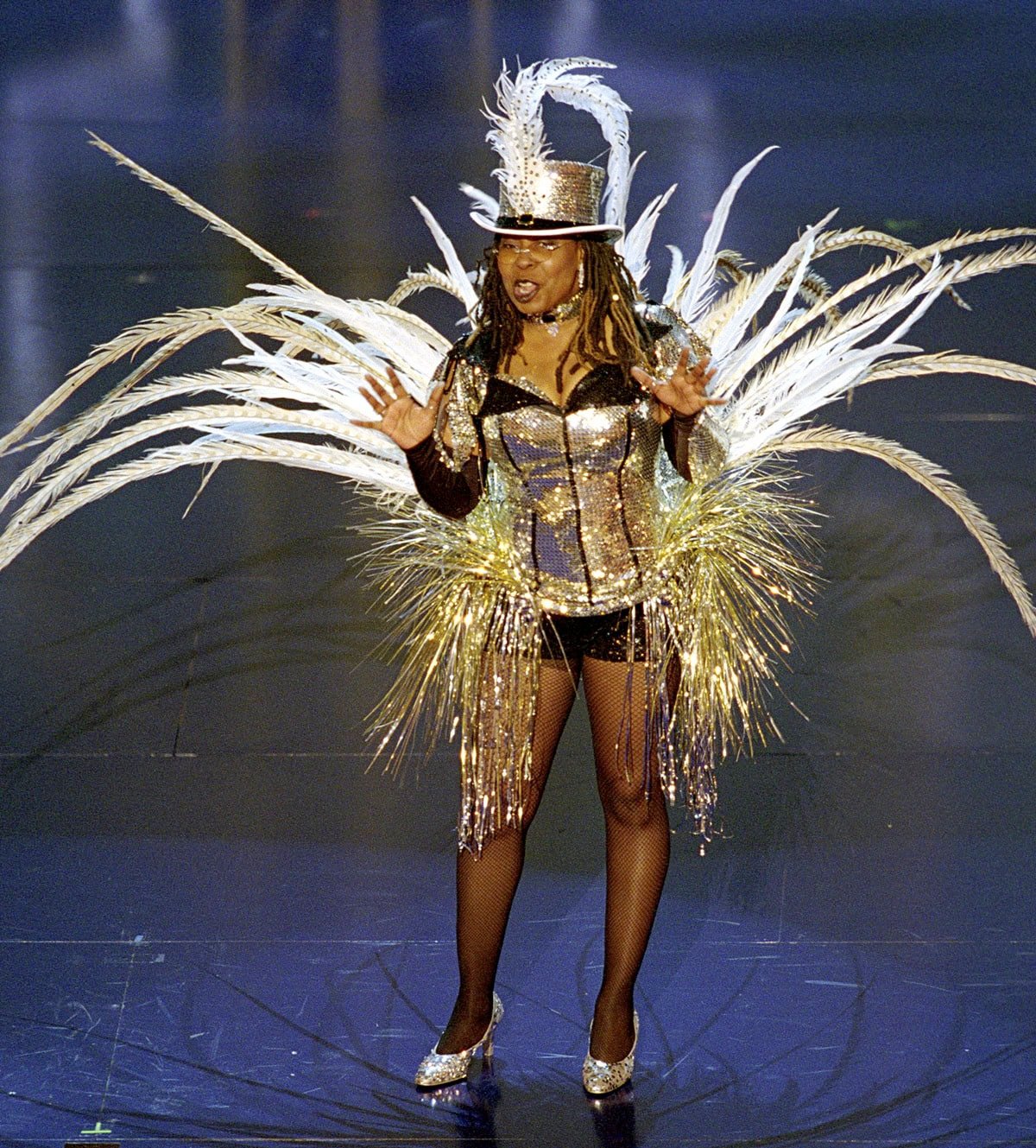 Whoopi Goldberg makes a sparkling statement at the 74th Academy Awards in a feather-trimmed Moulin Rouge–inspired showgirl costume and glittering silver high heels on March 24, 2002