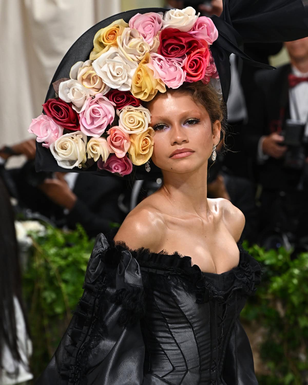 Zendaya is giving rich grieving woman energy as she pairs her black gown with a bouquet hat by Philip Treacy