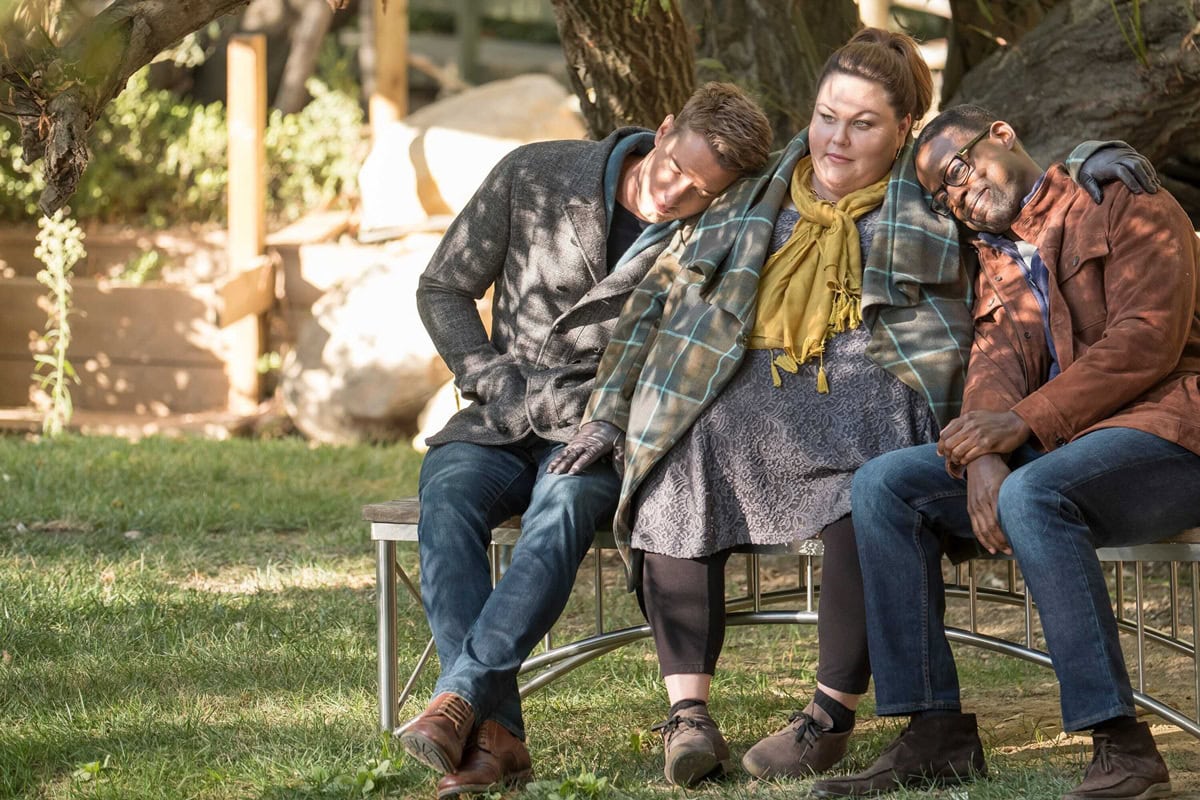 Justin Hartley as Kevin Pearson, Chrissy Metz as Kate Pearson, and Sterling K. Brown as Randall Pearson share a heartfelt moment in This Is Us Episode 2x11, with Hartley in brown leather lace-up shoes, Metz in practical taupe lace-up flats, and Brown in suede desert boots that ground their casual looks