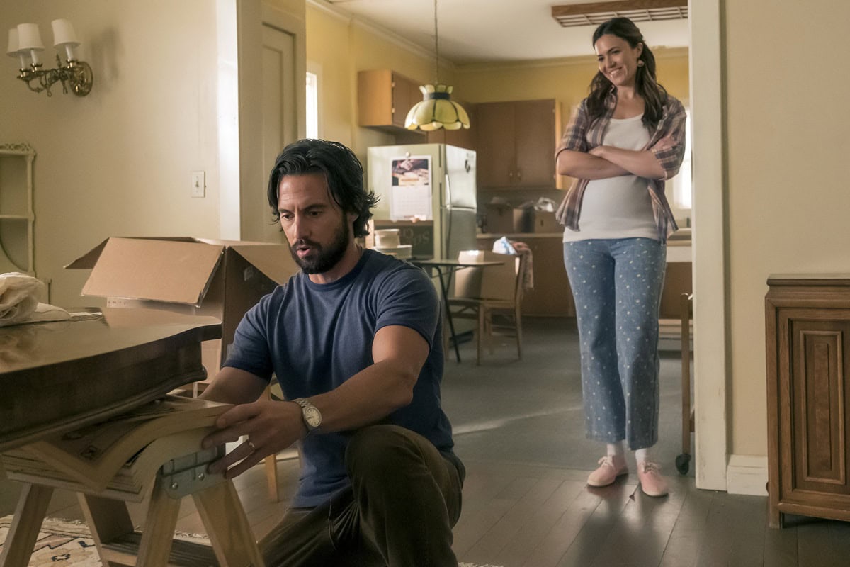 Mandy Moore as Rebecca Pearson in This Is Us Episode 4x5, dressed in a casual plaid shirt layered over a white tank and floral-print blue jeans, paired with comfy pink lace-up sneakers that highlight her relaxed, at-home style alongside Milo Ventimiglia’s Jack