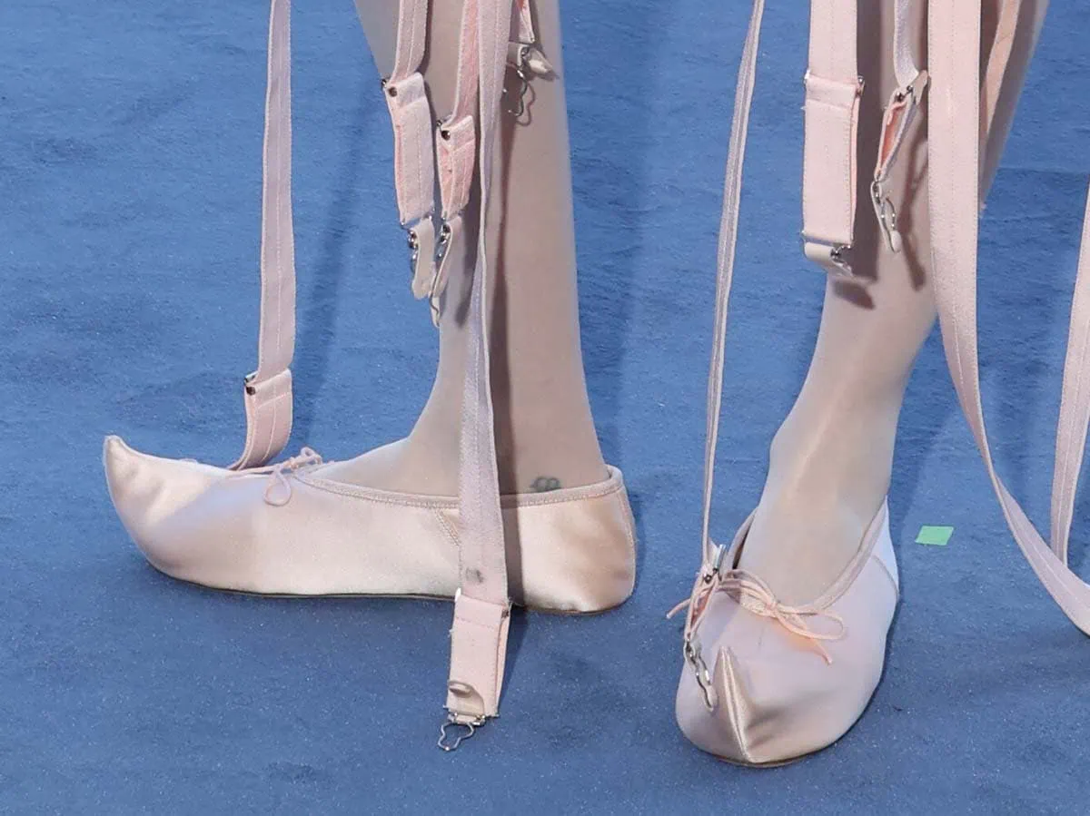 Cara Delevingne keeps her look coordinated, matching her conical bra with a pair of elf-like ballet flats