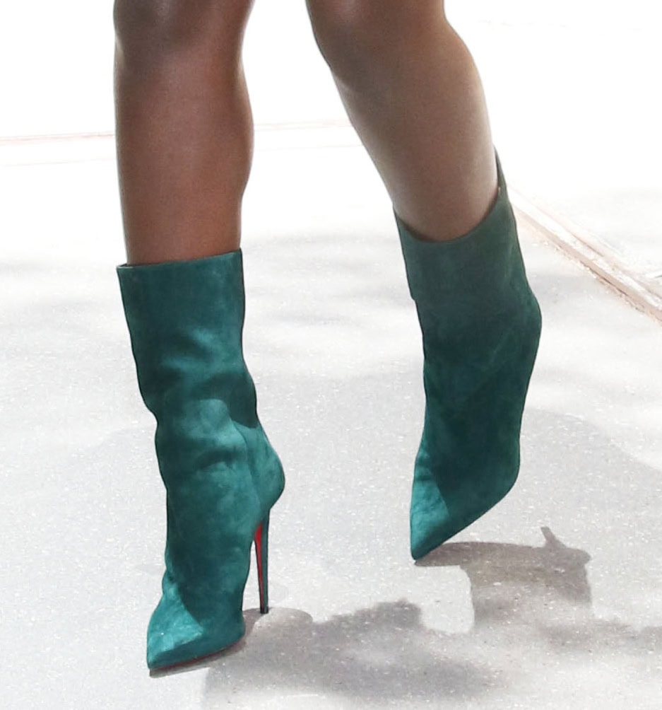 Jodie Turner-Smith completes her vintage ensemble with the Christian Louboutin Astrilarge boots in Vosges Green suede