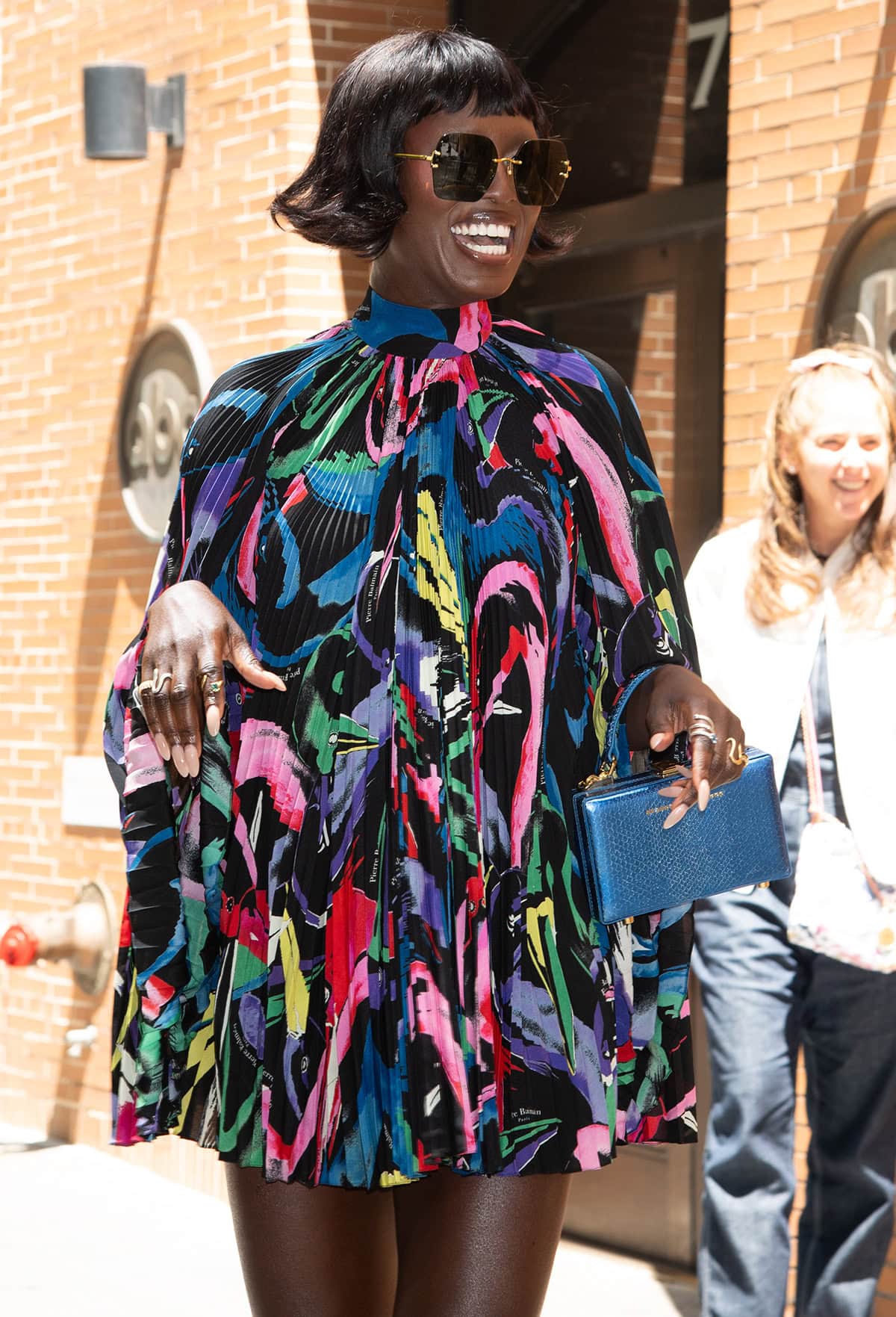 Jodie Turner-Smith enhances the retro glamour by styling her rainbow-colored mini dress with oversized, square-shaped Linda Farrow sunnies