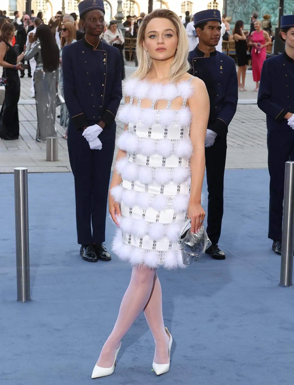 Joey King stuns in a space-age Givenchy mini-dress featuring a crystal-encrusted cage-like overlay with white pom poms at the 2024 Vogue World: Paris