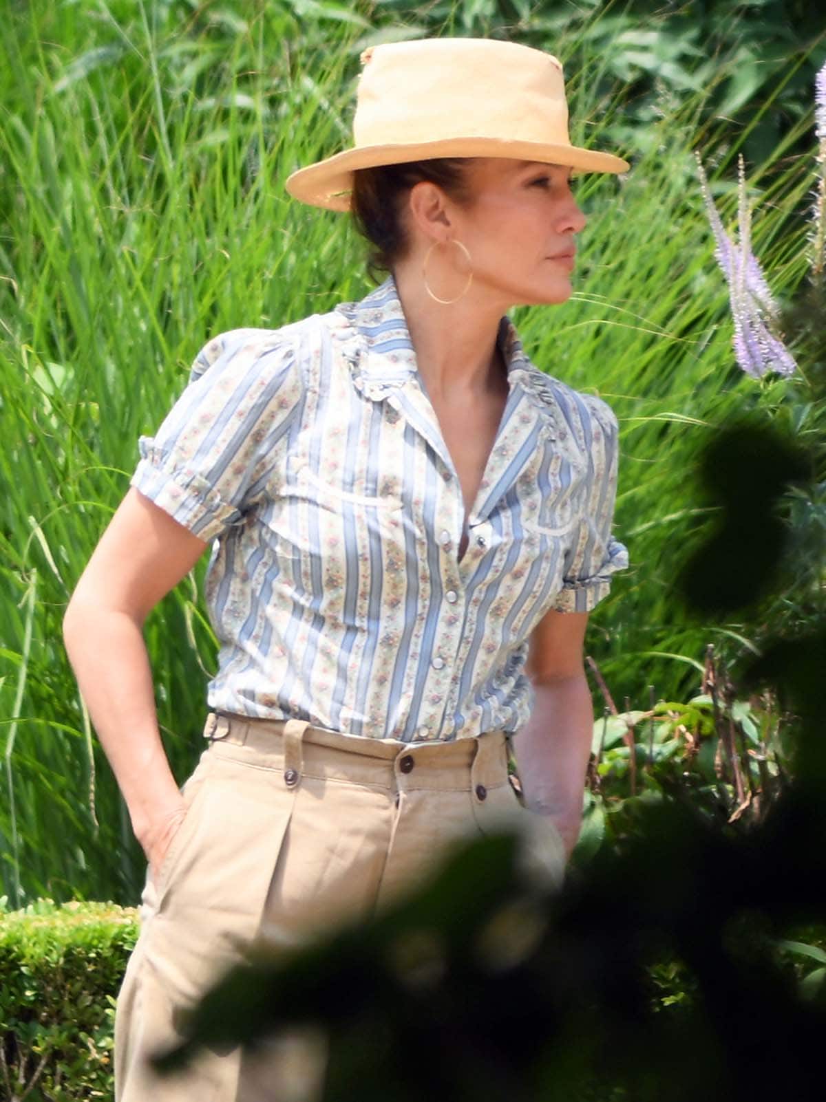 Jennifer Lopez looks chic in her summery floral and stripe blouse and straw hat for her low-key July 4th celebration