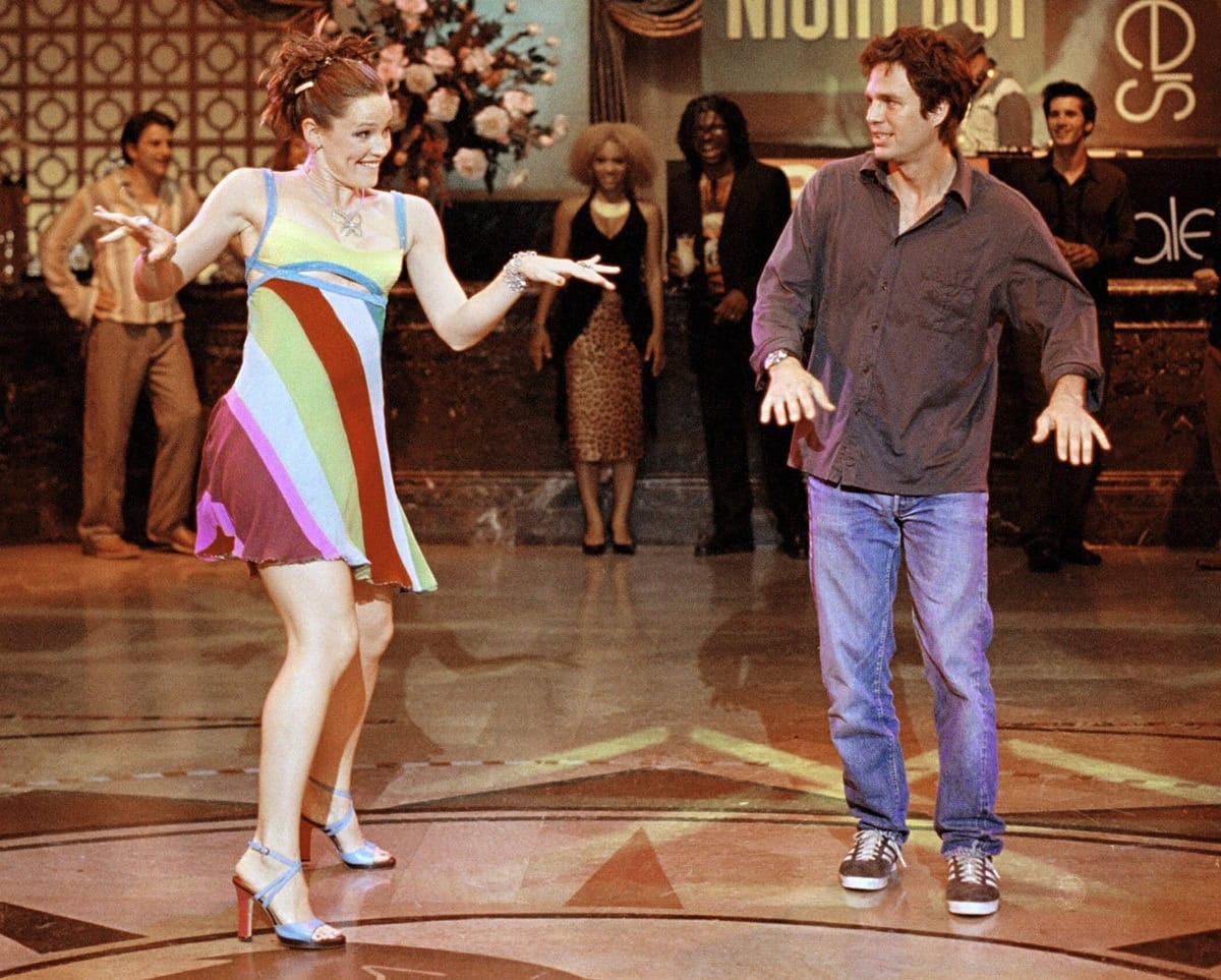 Jennifer Garner channels Y2K magic in a multicolored Versace minidress and blue strappy heels during the iconic "Thriller" dance scene in 13 Going on 30, blending teenage spirit with high-fashion flair