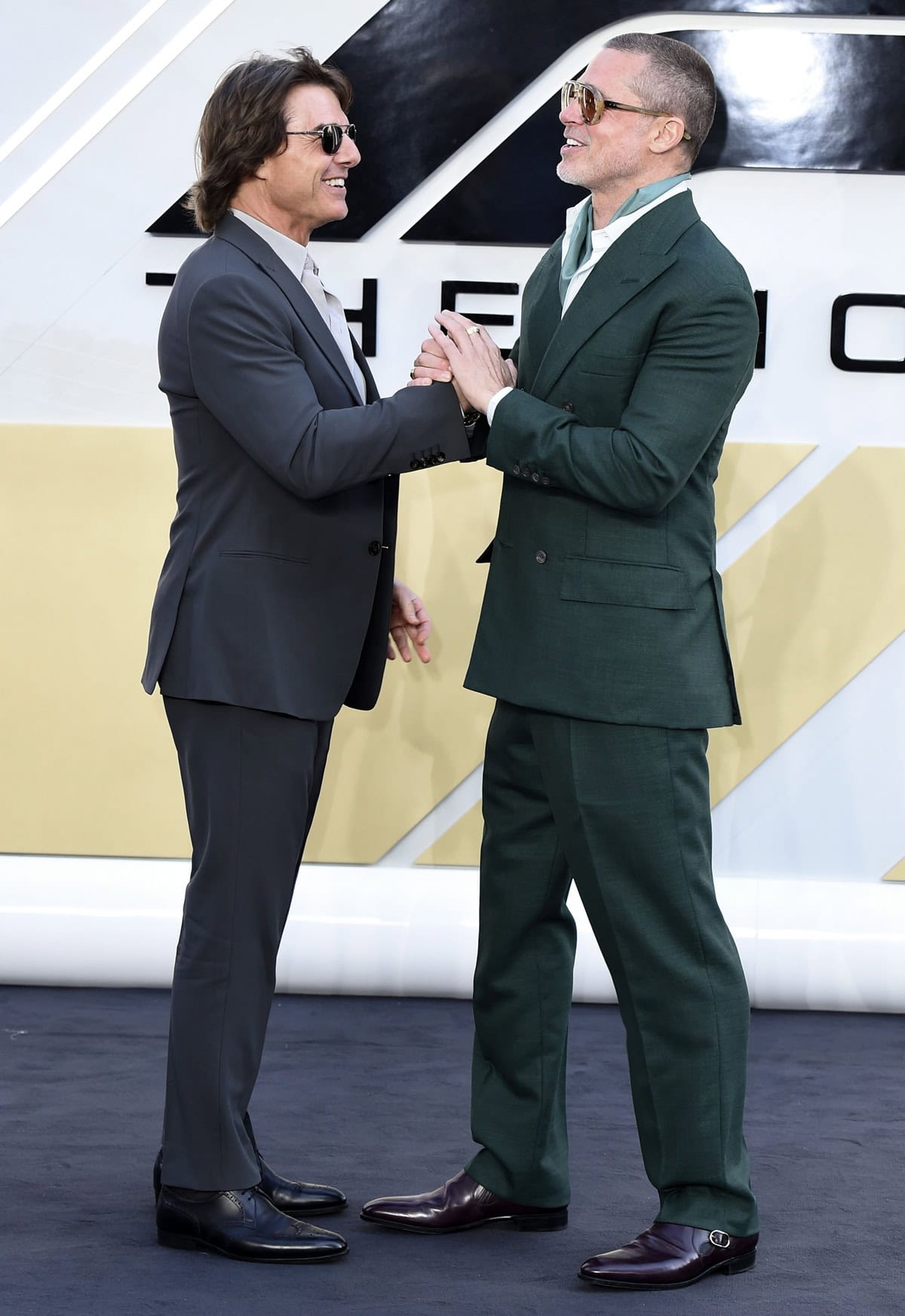 Standing next to Brad Pitt, Tom Cruise looked sharp in a tailored gray suit and heeled brogues, adding polish—and a few extra inches—to his premiere look