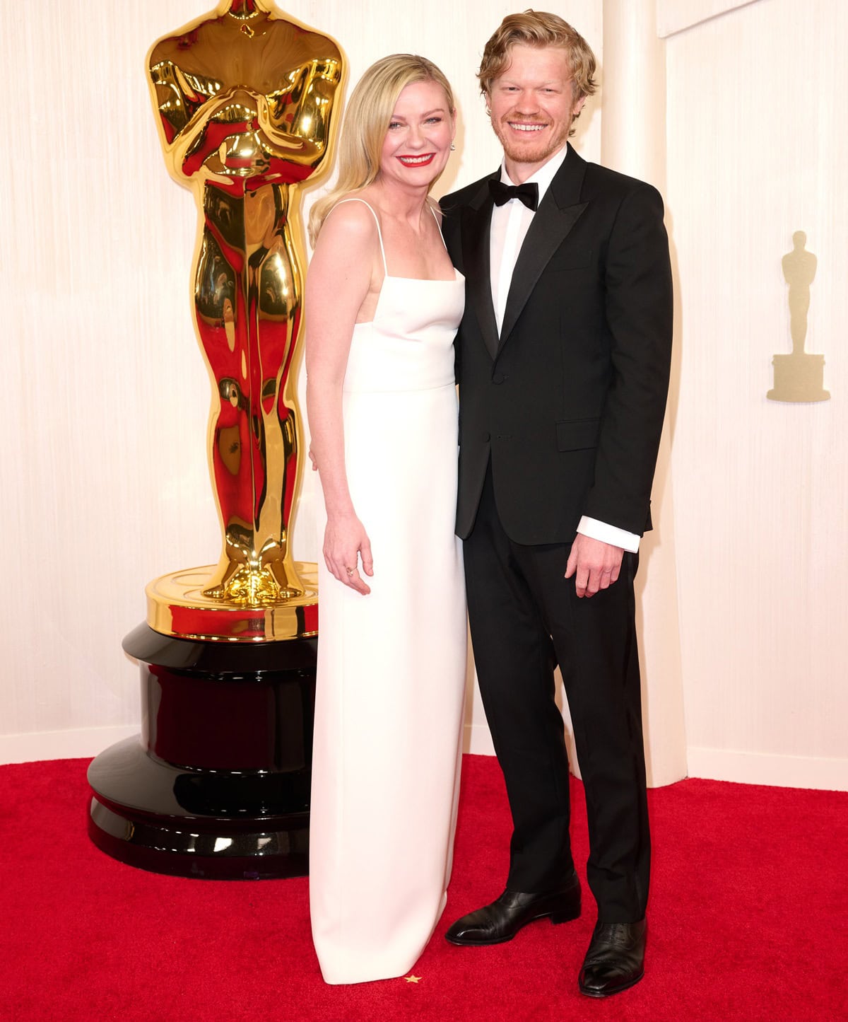 At the 96th Academy Awards on March 10, 2024, Kirsten Dunst and Jesse Plemons coordinated in classic black-and-white elegance at the Dolby Theatre, with Dunst stunning in a minimalist white Gucci gown and Plemons looking sharp in a timeless black tuxedo