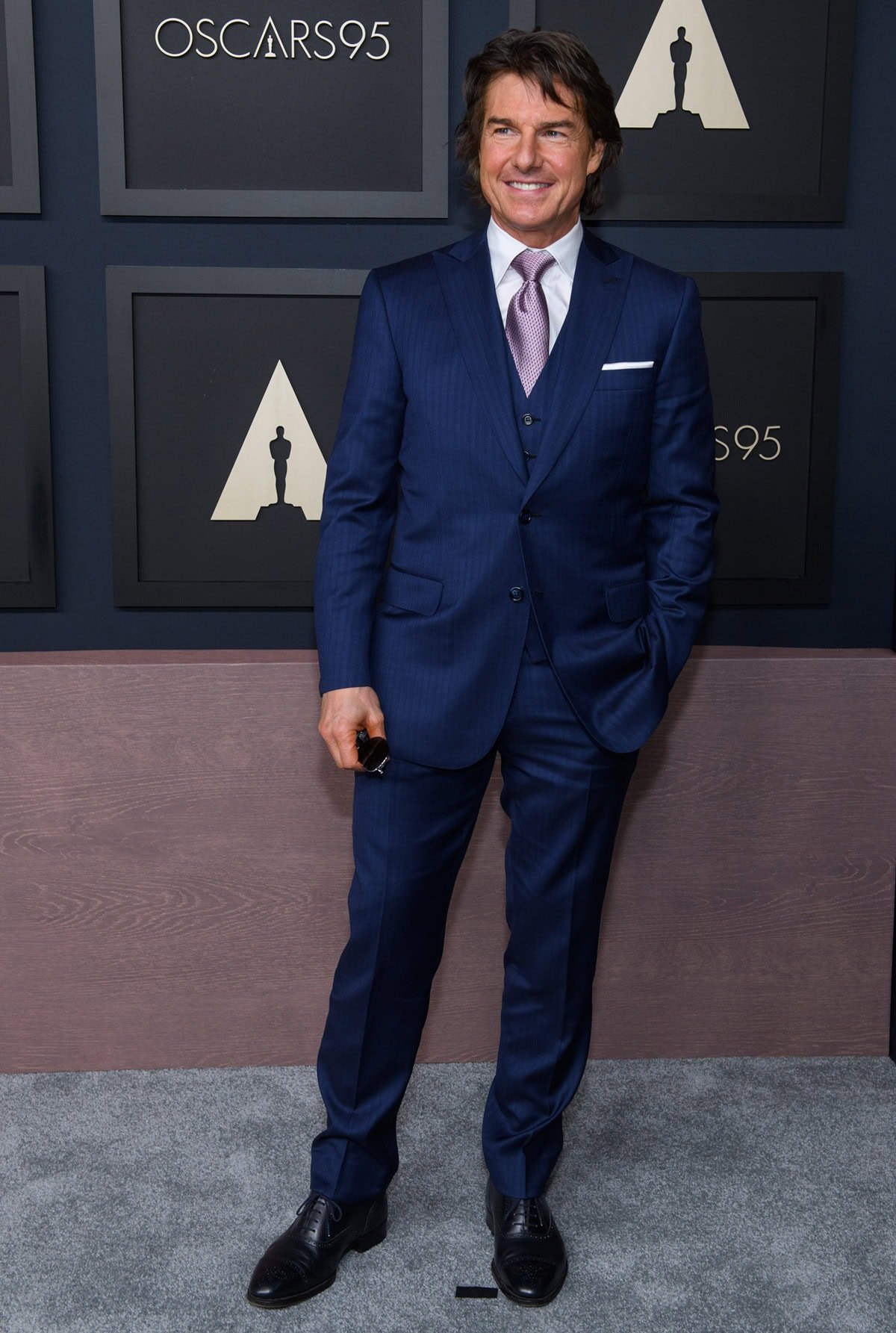 Tom Cruise exudes classic Hollywood polish in a navy three-piece pinstripe suit at the 2023 Oscars Nominees Luncheon, celebrating his Best Picture nomination for “Top Gun: Maverick”