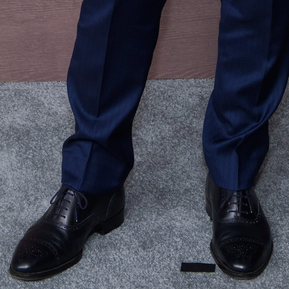 Cruise completes his red carpet look with black leather wingtip brogues featuring almond toes, decorative perforations, and subtly elevated heels for a refined, height-boosting finish