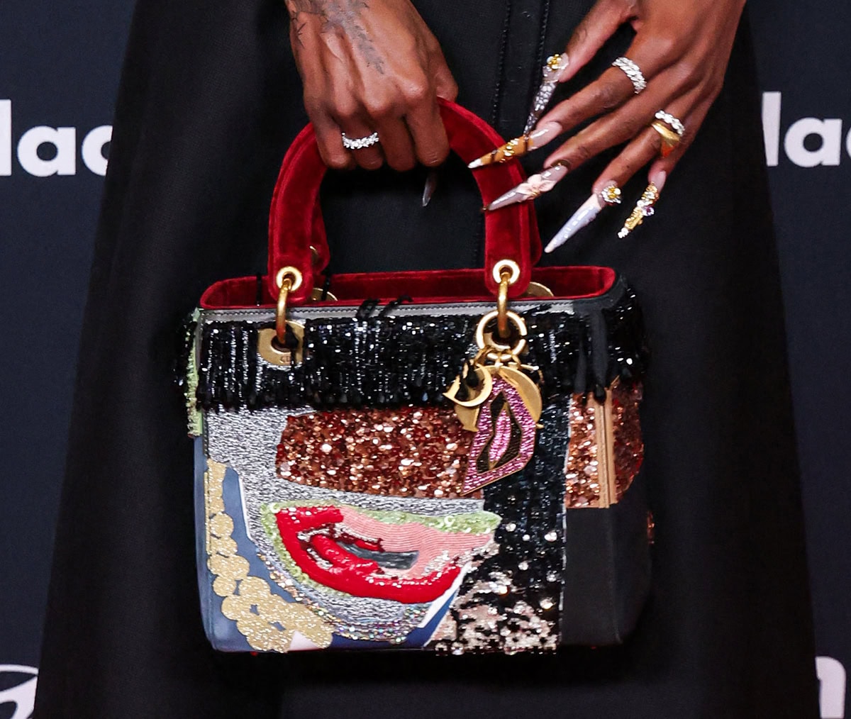 Cynthia Erivo adds a whimsical touch to her all-black look by carrying a Lady Dior bag designed by African-American artist Mickalene Thomas