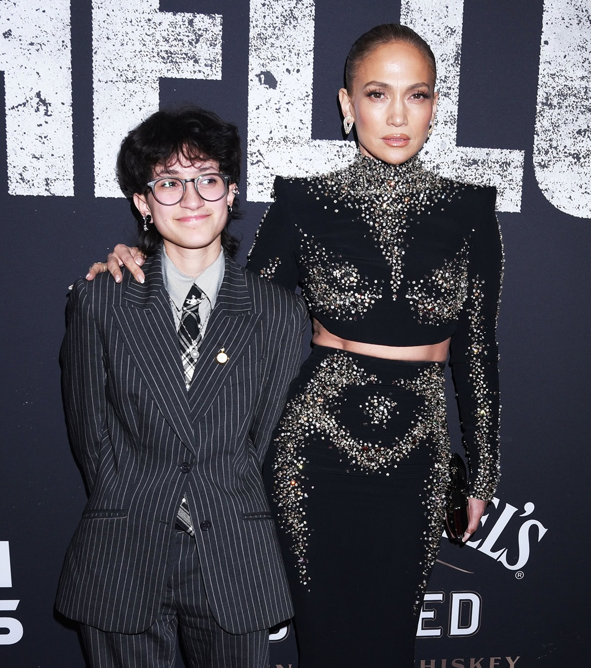 Jennifer Lopez is pictured with her daughter Emme clad in a pinstriped suit, shirt, and plaid necktie