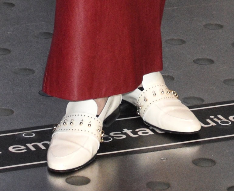 Olivia Palermo completes her red-and-white ensemble with white AGL loafers featuring rings and stud accents