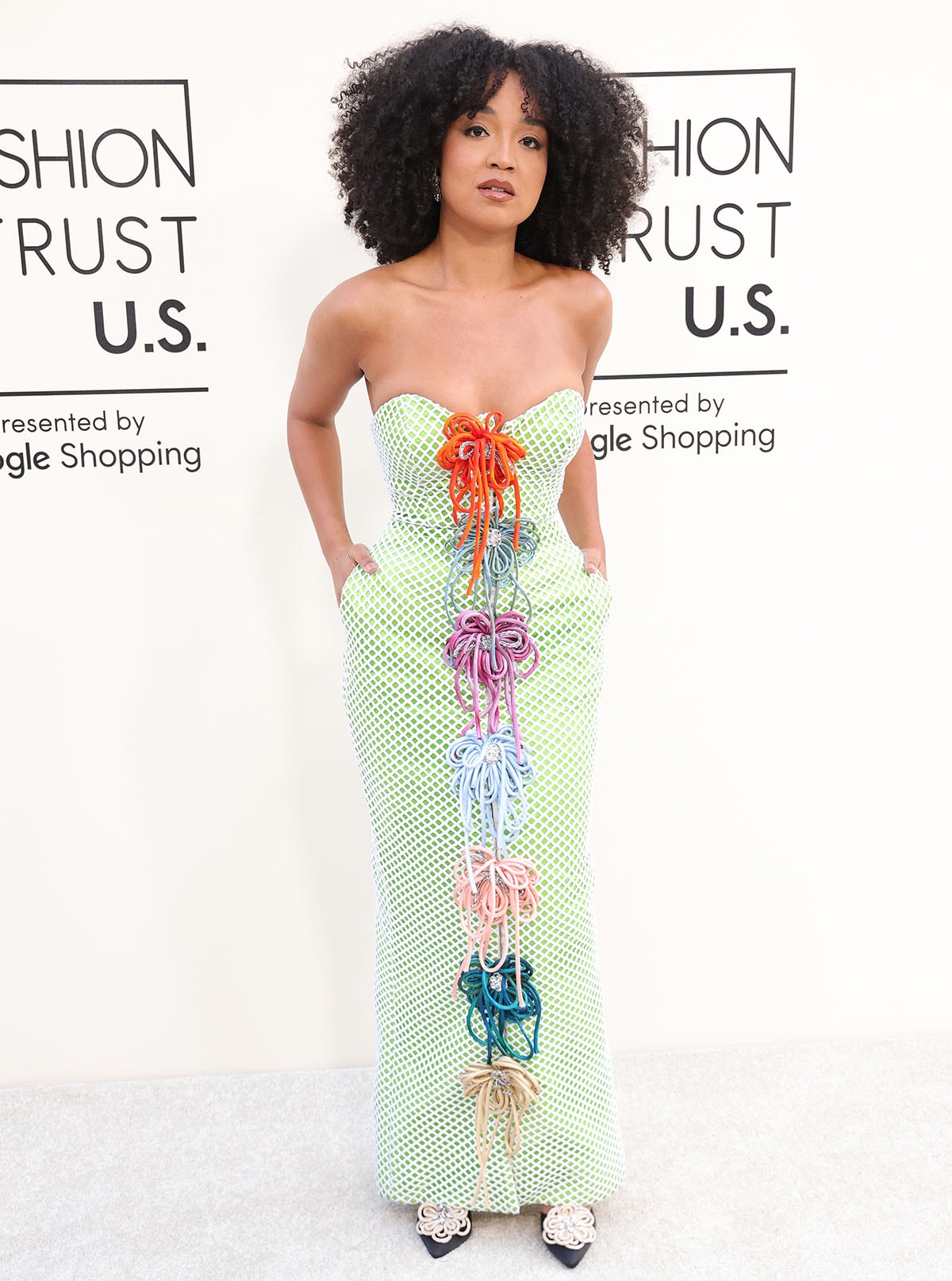 Aisha Dee teams her unique pumps with a pastel green strapless gown featuring Harbison Studio’s signature colorful floral accents