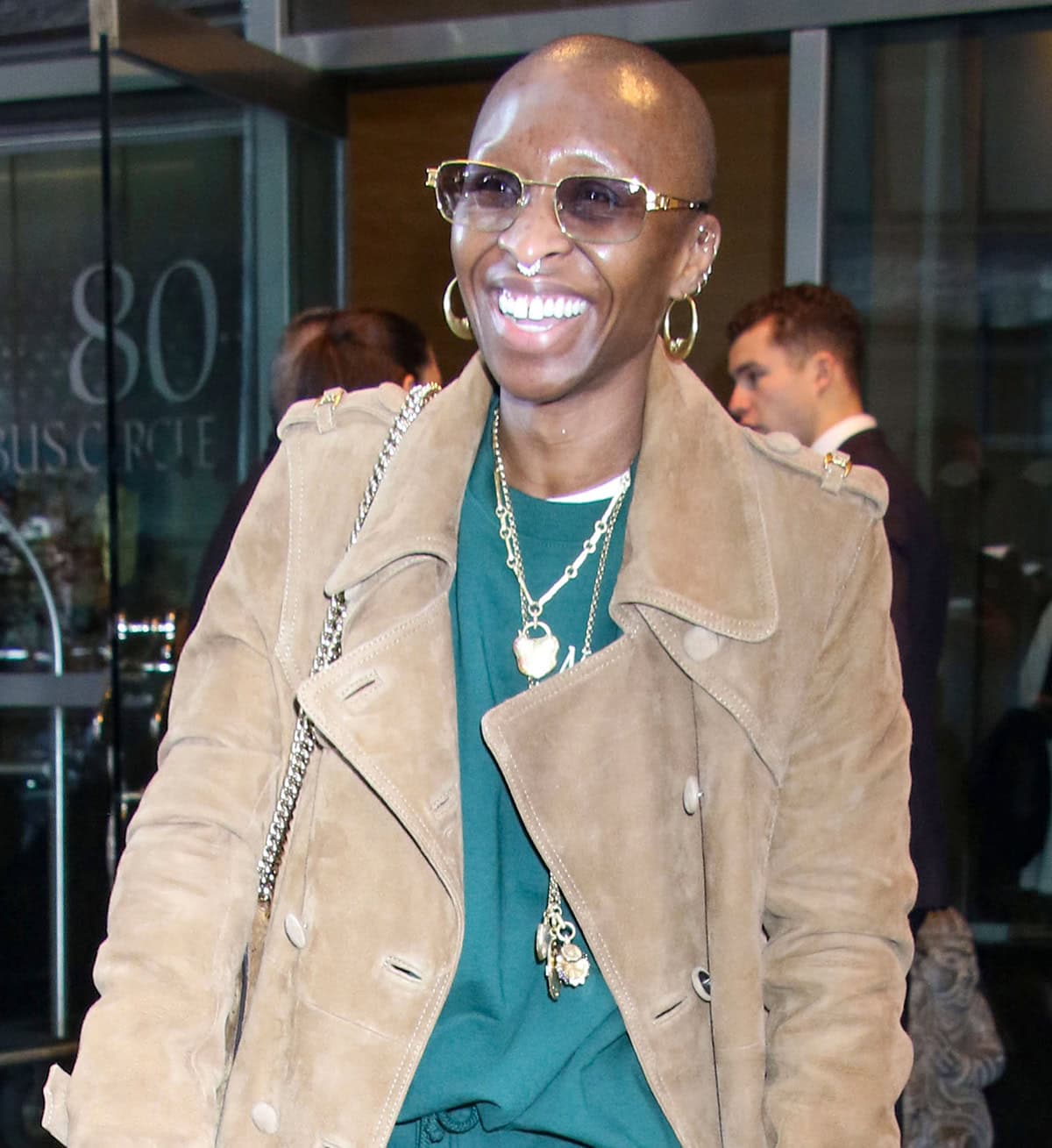 Cynthia Erivo enhances her streetwear with long gold chain necklaces, hoop earrings, and a nose ring