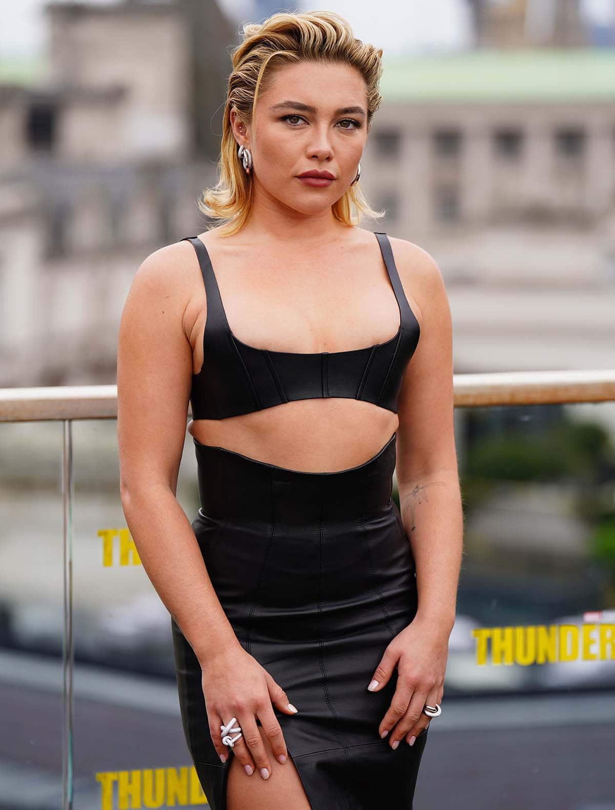 Florence Pugh adds sparkles to her all-black look with Engelbert jewelry, wearing chunky hoops and rings with diamonds