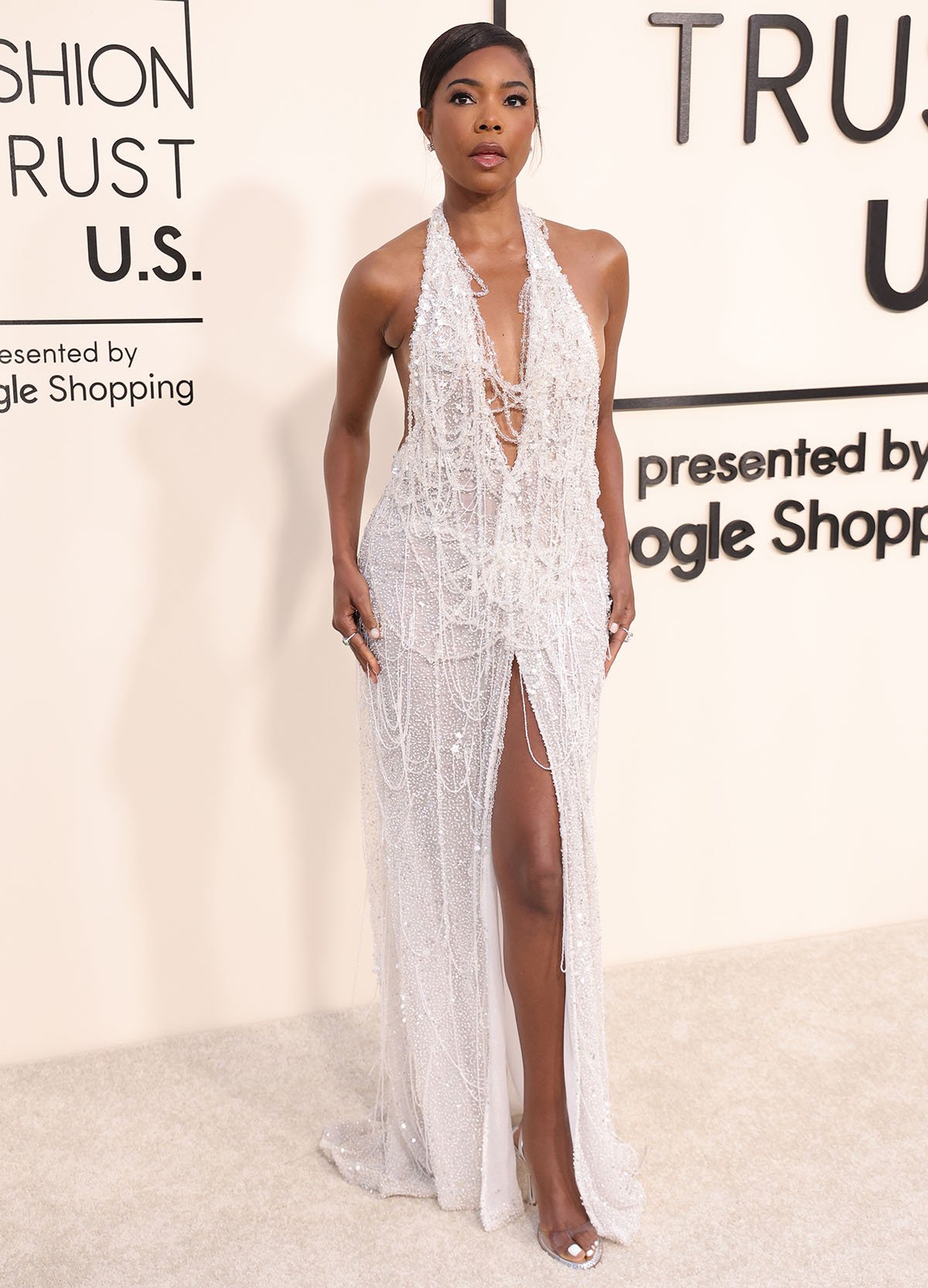 Gabrielle Union teams her minimalist sandals with a beaded white plunging gown by Celia Kritharioti