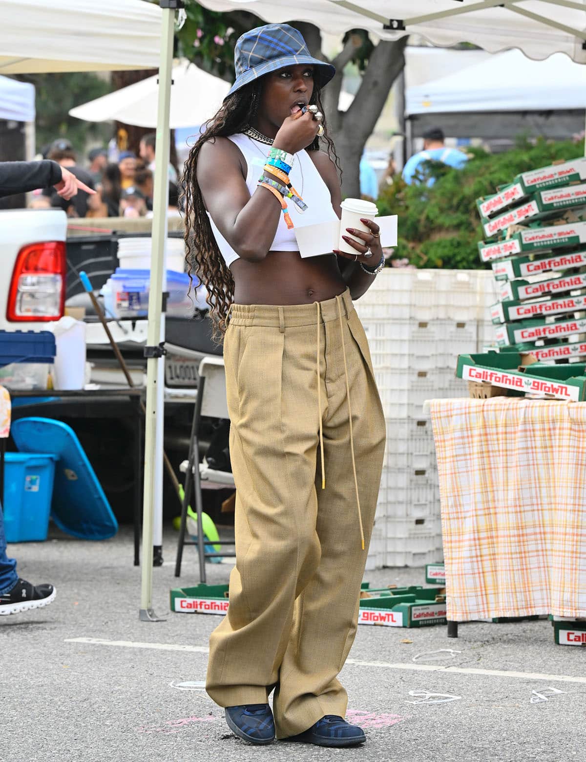 Jodie Turner-Smith turns heads at the Los Angeles Farmers Market on April 13, 2025, in a crisp white crop top, wide-leg khaki trousers, and matching Burberry check sneakers and bucket hat