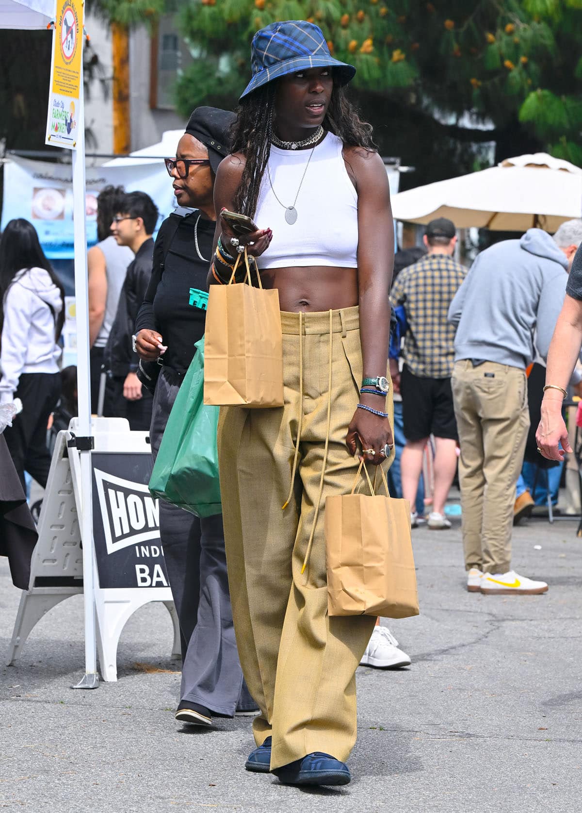 Jodie Turner-Smith flaunts her toned arms and abs in a 1990s classic combination featuring a cropped white tank top and baggy khaki pants