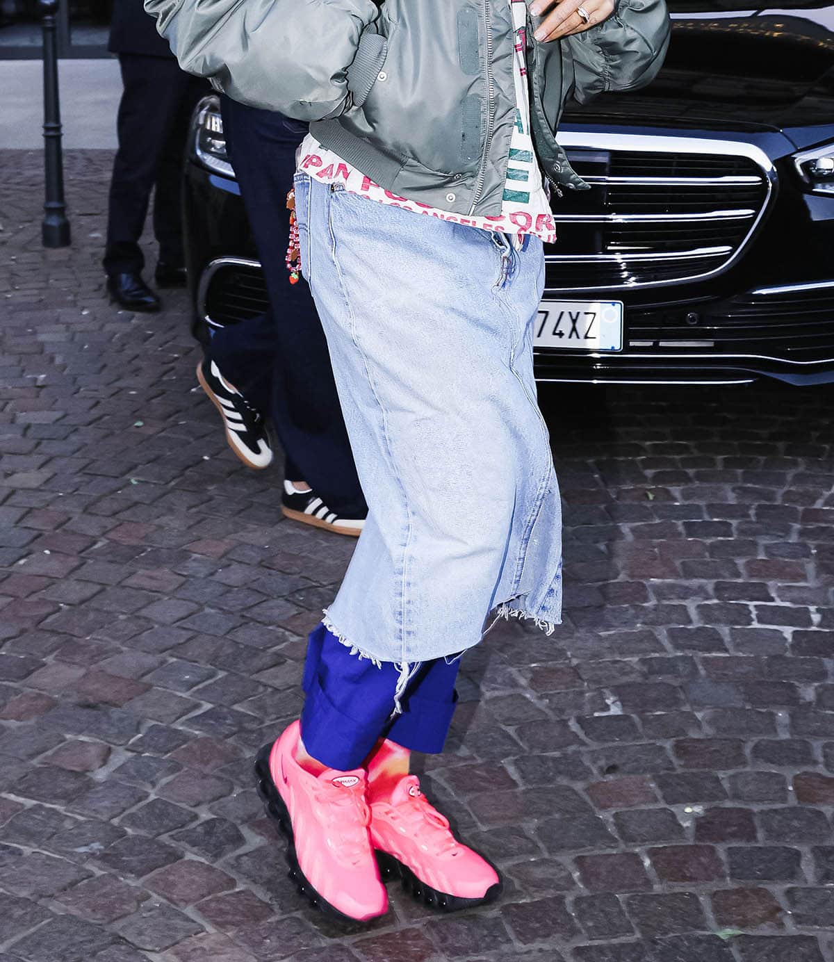 Rita Ora continues her layered look, pairing a denim midi skirt with electric blue pants