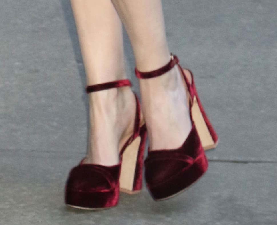 Anna Kendrick towers in a pair of burgundy velvet pumps with thick platforms and block heels by Malone Souliers