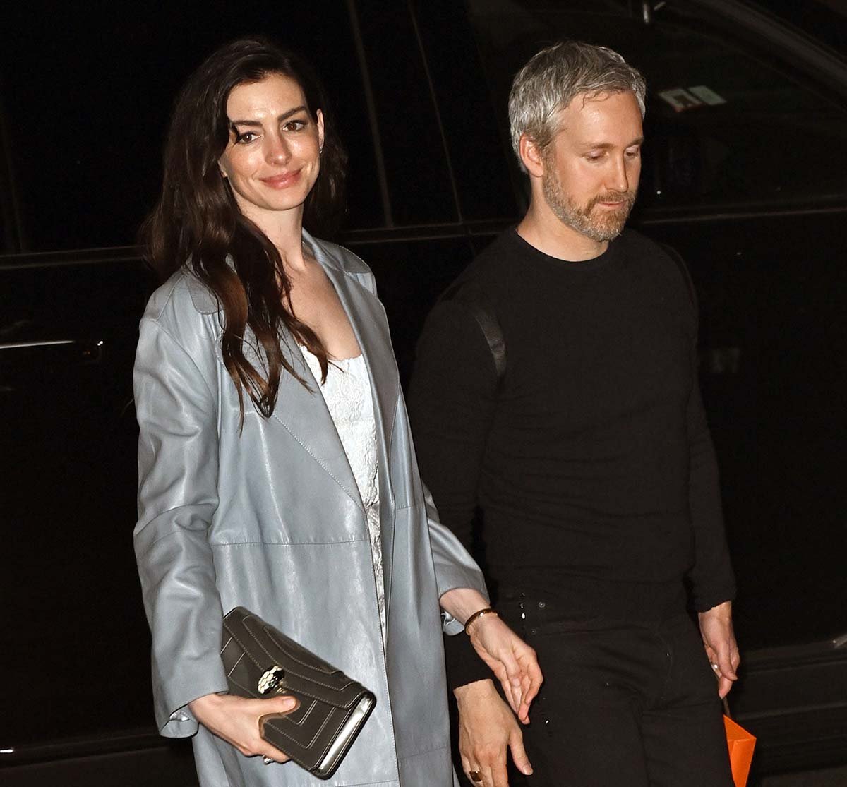 Anne Hathaway keeps the rest of her look simple, skipping any elaborate jewelry and carrying a silver Bulgari clutch with a palladium-plated snakehead closure