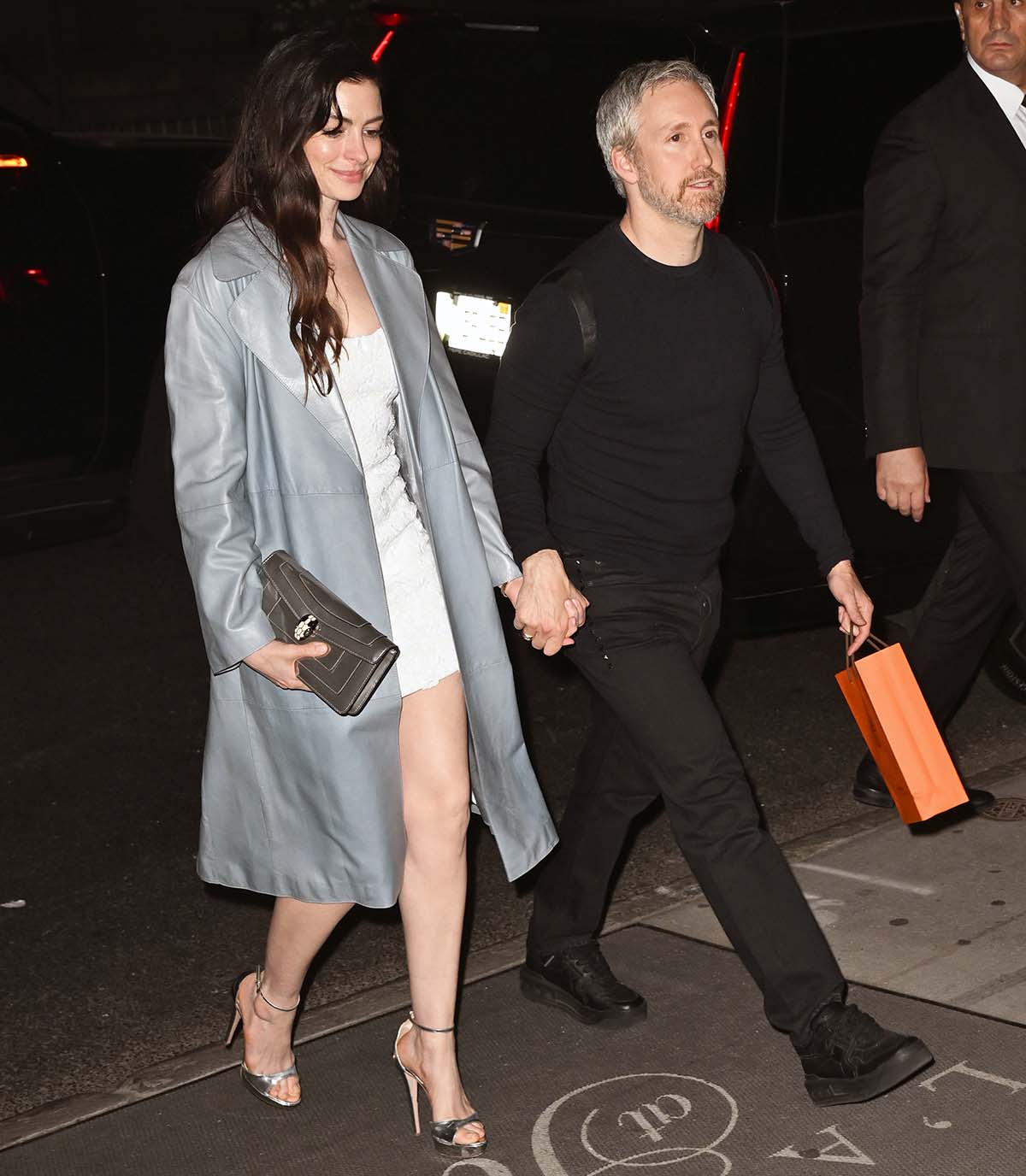 Anne Hathaway, with her husband Adam Shulman, looks stunning in an icy blue-gray duster coat with a white floral sequin mini dress by Michael Kors underneath