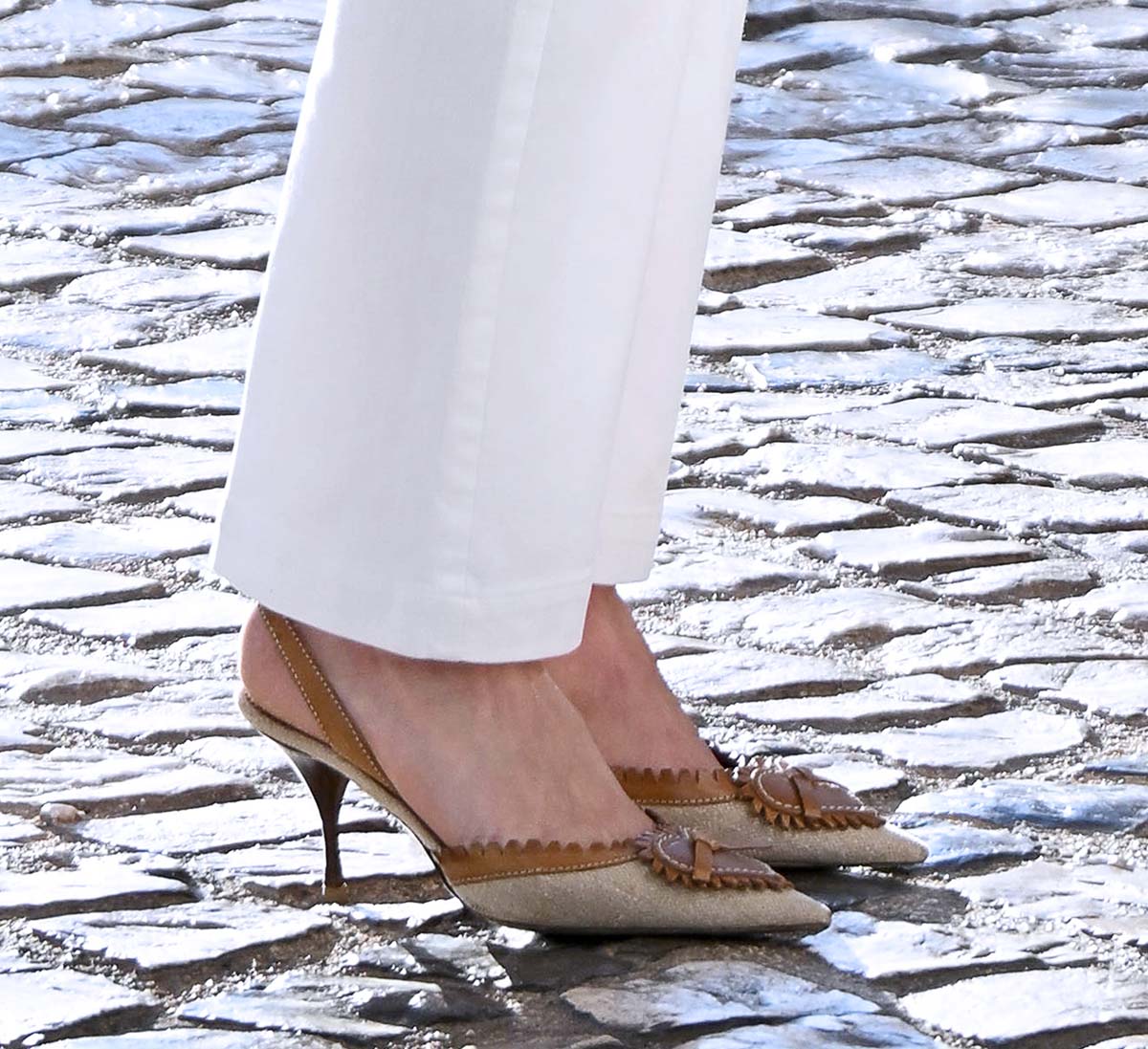 Bella Hadid teams her white ensemble with vintage 1990s Saint Laurent pumps from the Rive Gauche collection featuring a raffia upper with brown leather trims and a heart cutout