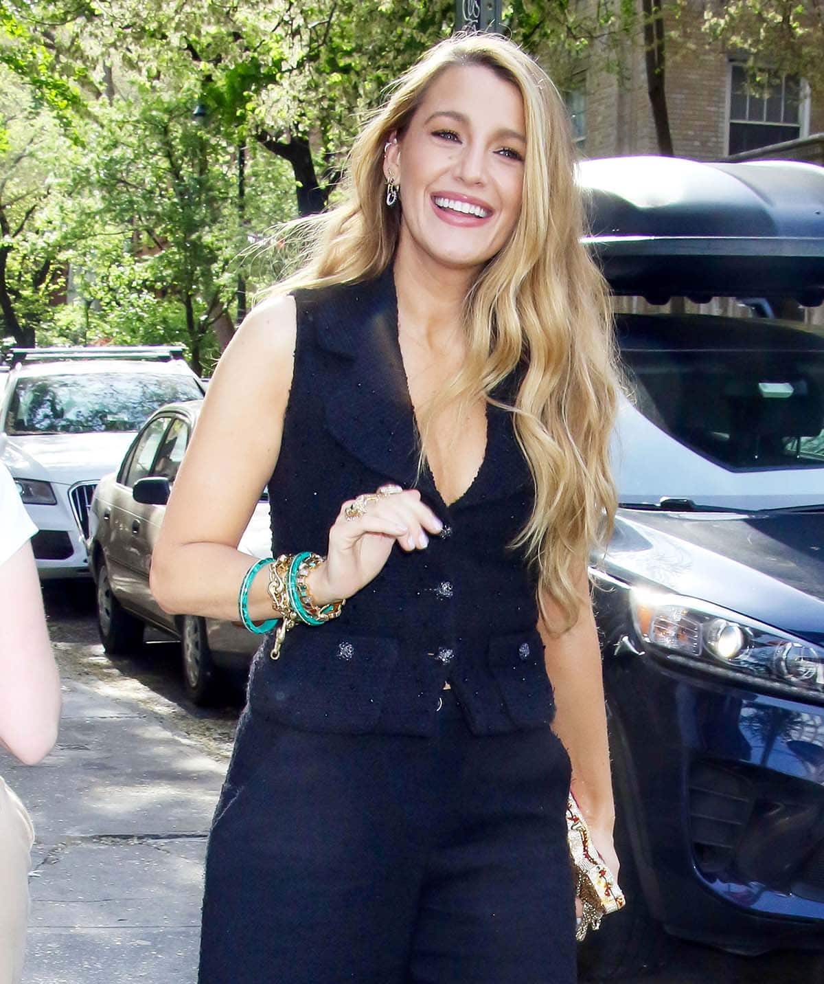 Blake Lively gives her chic look a quirky touch with a Judith Leiber Pepperoni Pizza clutch, multiple bracelets from Brent Neale, and earrings from Maria Tash
