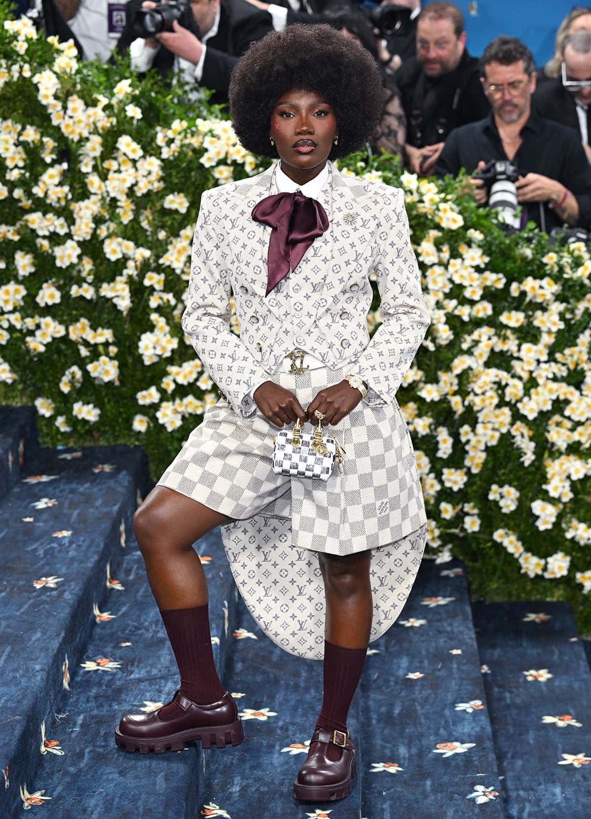 Doechii embraces logomania in a white monogrammed waistcoat and tailcoat with Damier check shorts