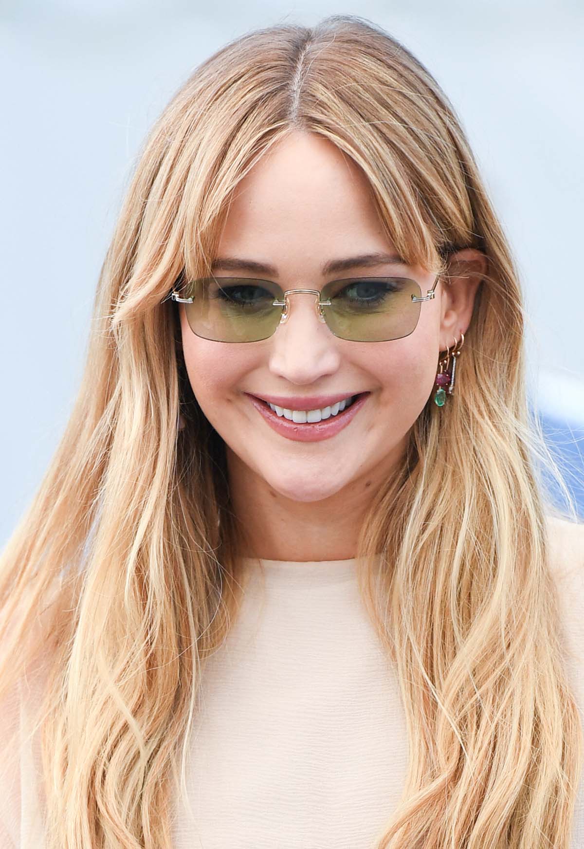 Jennifer Lawrence styles her summery bohemian look with green-tinted sunnies by Olivier Peoples and colorful gemstone jewelry by Irene Neuwirth