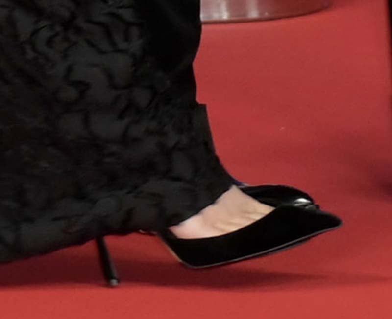 Kylie Jenner slips into a pair of black suede pointed-toe mules with a Mary Jane strap across the foot and slim stiletto heels