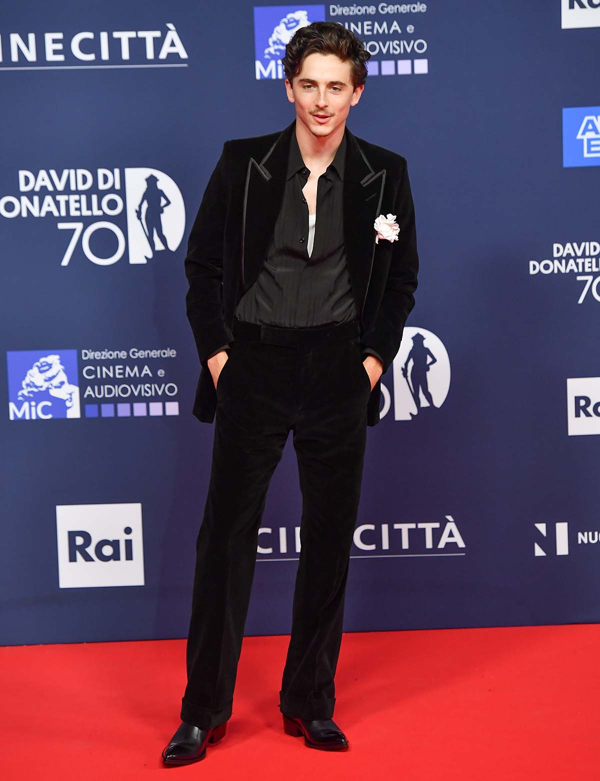 Timothee Chalamet looks handsome in a black velvet Tom Ford suit with a black Oxford shirt and black dress shoes