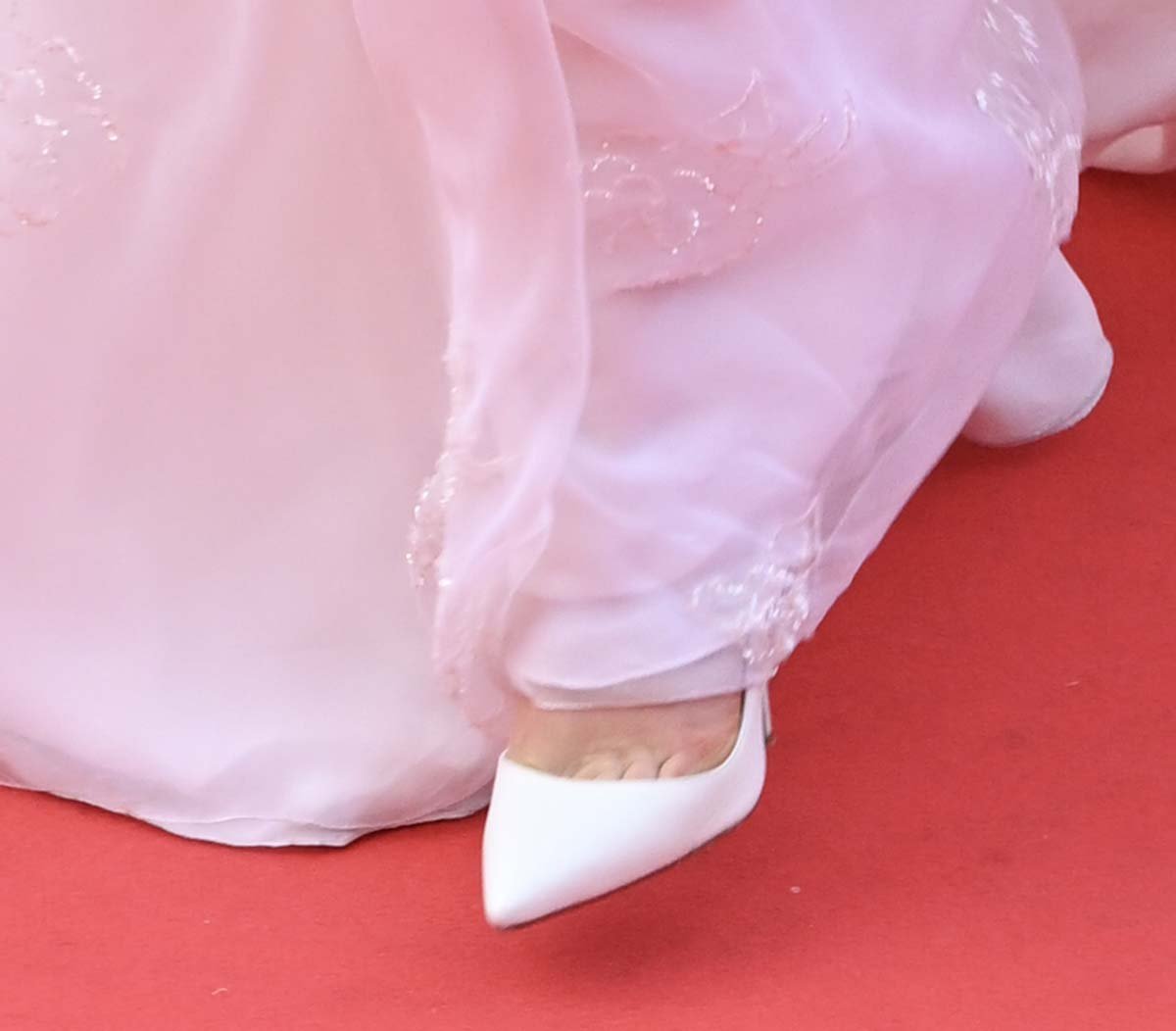 Zoey Deutch completes a cohesive look by pairing her stunning white gown with white Christian Louboutin Iriza pumps