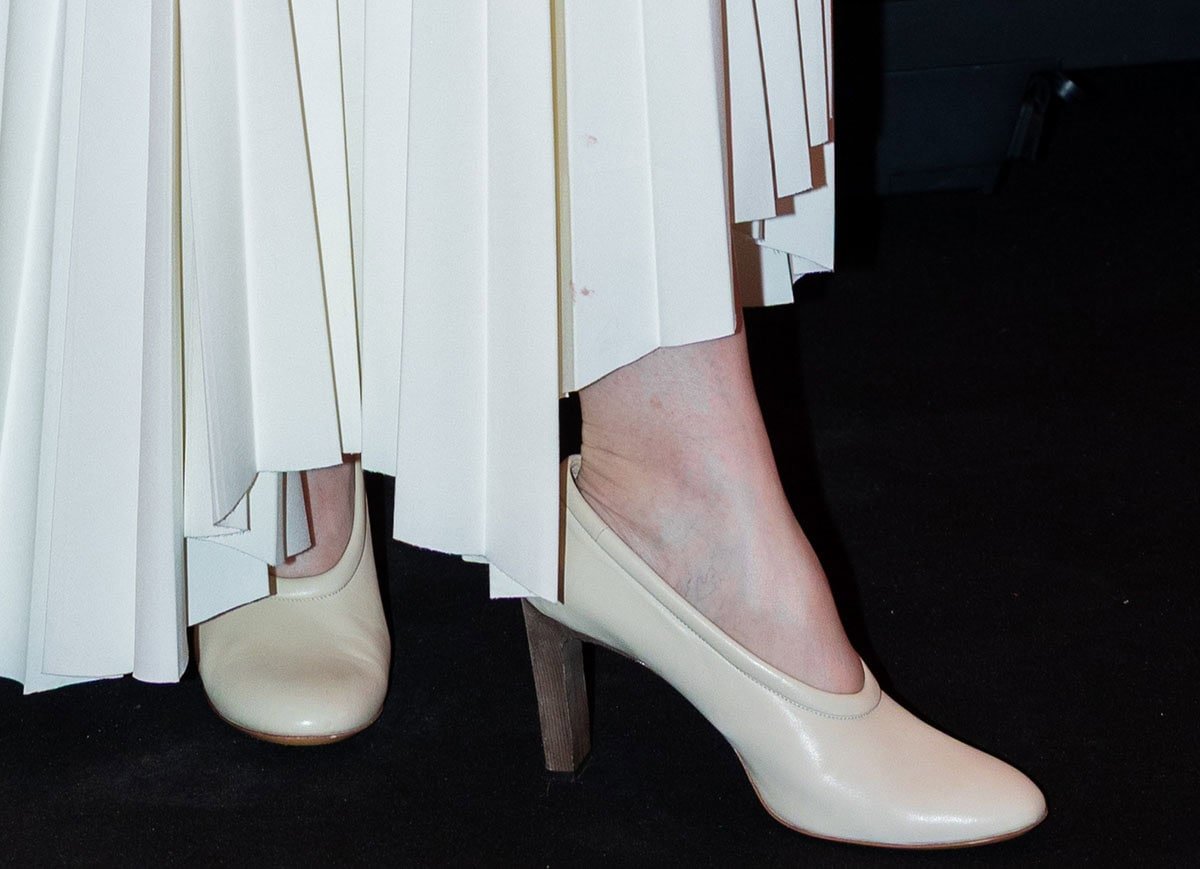 Cynthia Nixon pairs her modern outfit with classic beige pumps by Tod's featuring a rounded, padded topline, almond toes, and wooden block heels