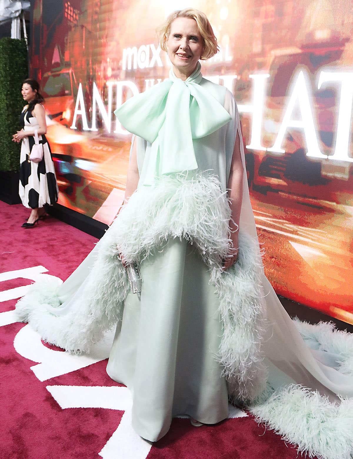 Cynthia Nixon steals the show at the AJLT season 3 New York photocall in a mint green gown by Richard Quinn featuring an oversized bow at the high neckline and a sheer cape with feather trims
