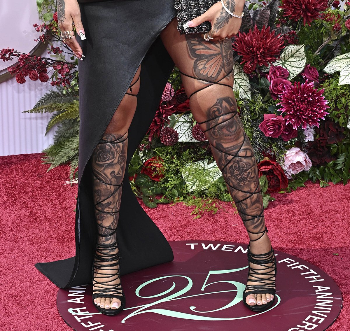 GloRilla shows off her tattooed legs in strappy wraparound open-toe sandals with thin leather ties extending to her thighs