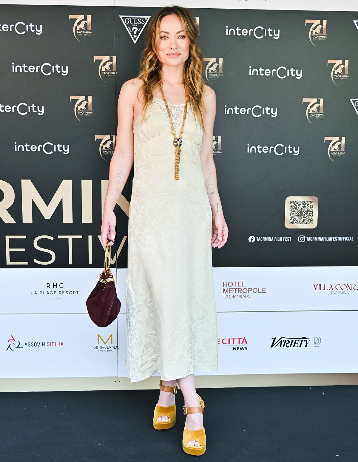 Olivia Wilde completes her ethereal boho look with metallic pearl satin platform sandals by Prada featuring peep toes, thick platforms, and block heels