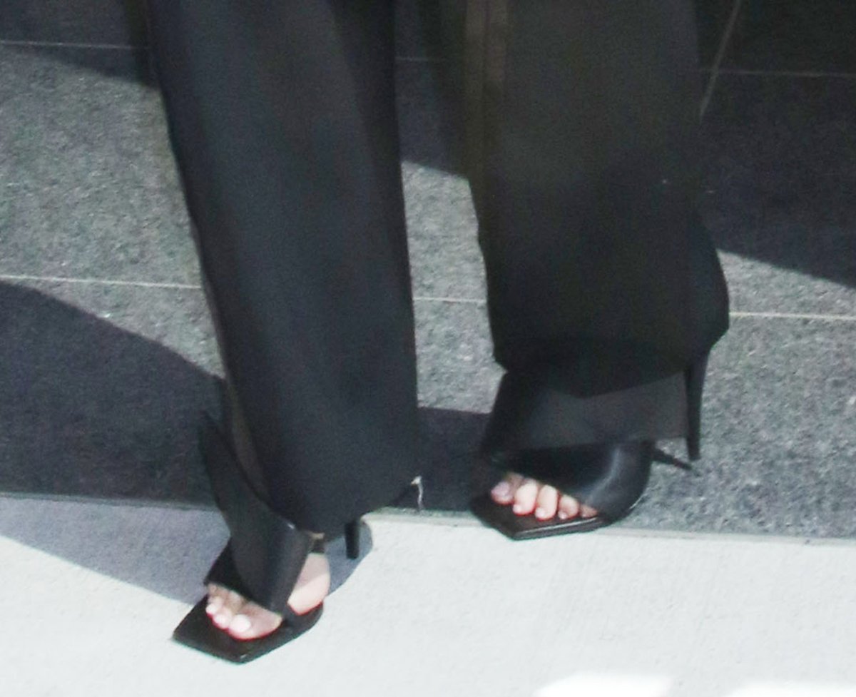 Charlize Theron commands attention with her architectural Givenchy sandals featuring open square toes and a large twisted ribbon wrapping the foot