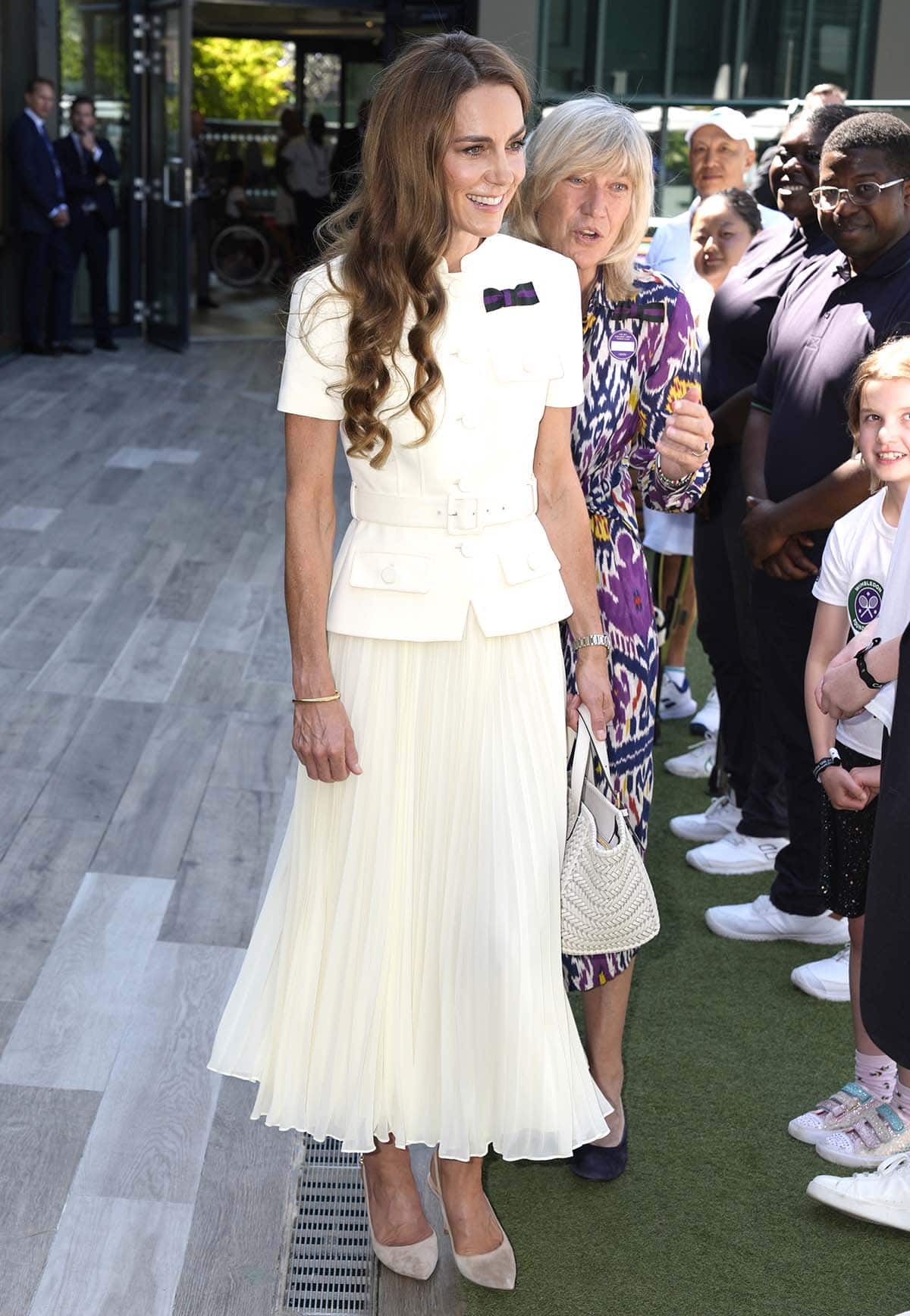 Kate Middleton looks effortlessly elegant in a cream Self-Portrait dress featuring a tweed belted bodice and a pleated ankle-length skirt