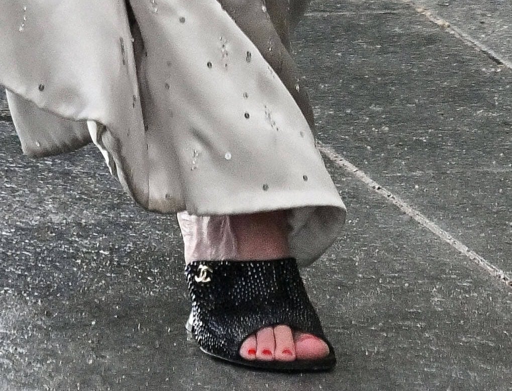 Kirsten Dunst teams her shimmering silver gown with glittery black open-toe Chanel mules, complementing the rest of her accessories