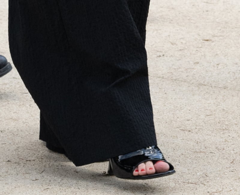 Kirsten Dunst completes her ensemble with black patent open-toe mule sandals, showcasing her red pedicure
