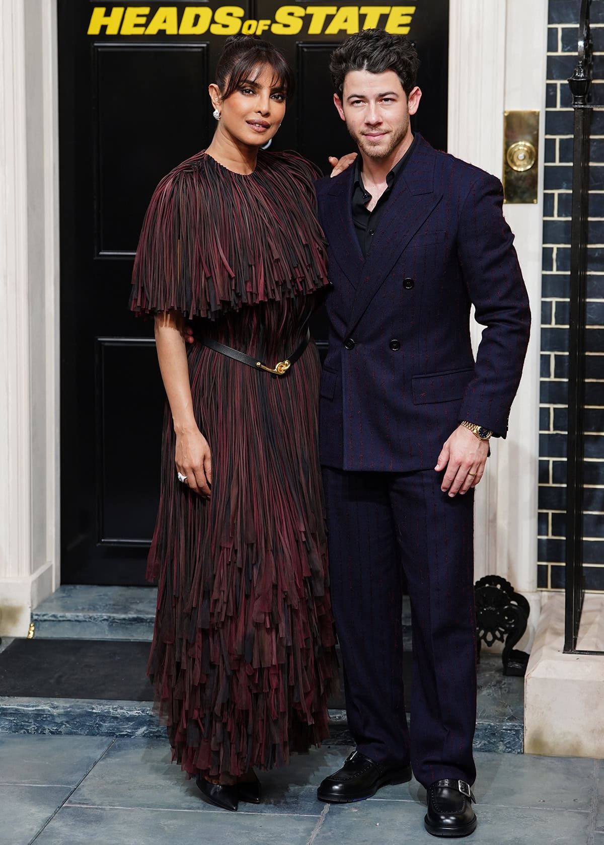 Priyanka Chopra, with husband Nick Jonas, wears a heavily fringed dress in red and black hues by Burberry at the screening of Heads of State at the BFI Southbank in London