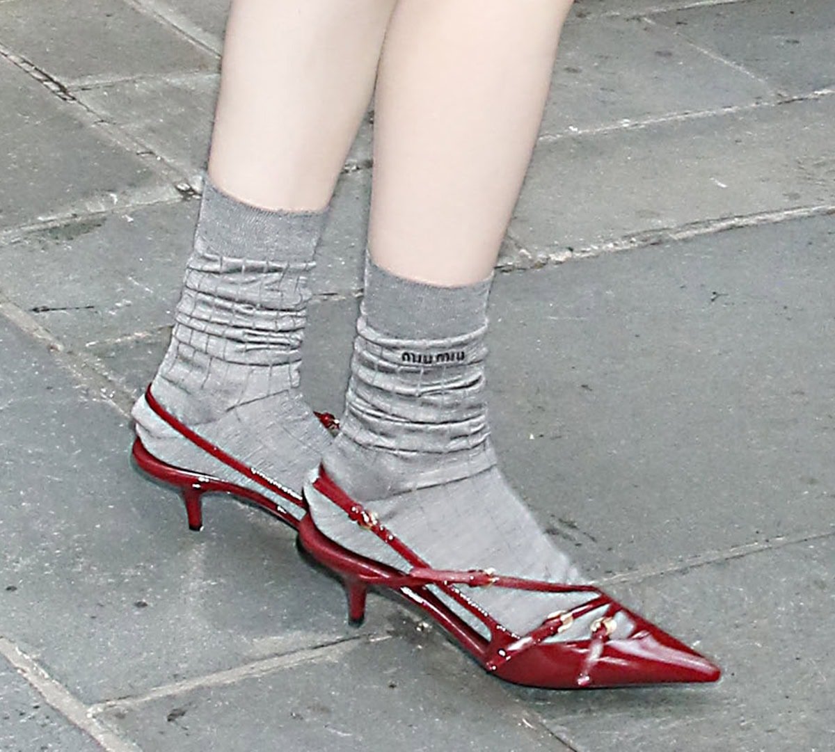 Rachel Brosnahan enhances her look's retro schoolgirl aura with gray Miu Miu socks and red patent slingback pumps with slim buckled straps