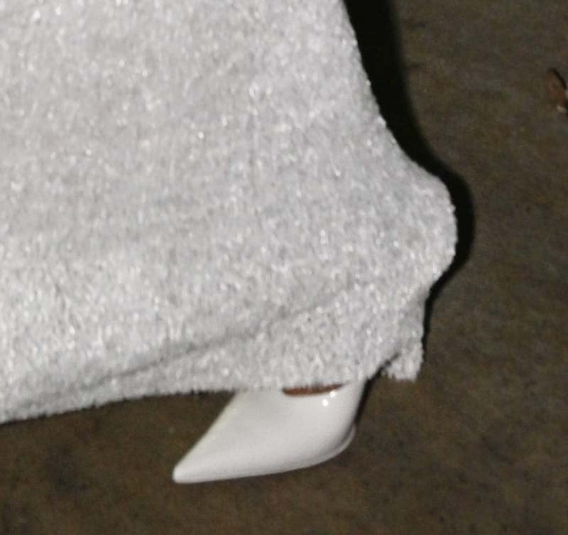 Rihanna pairs her white Alaïa ensemble with shiny white pointed-toe pumps by Amina Muaddi